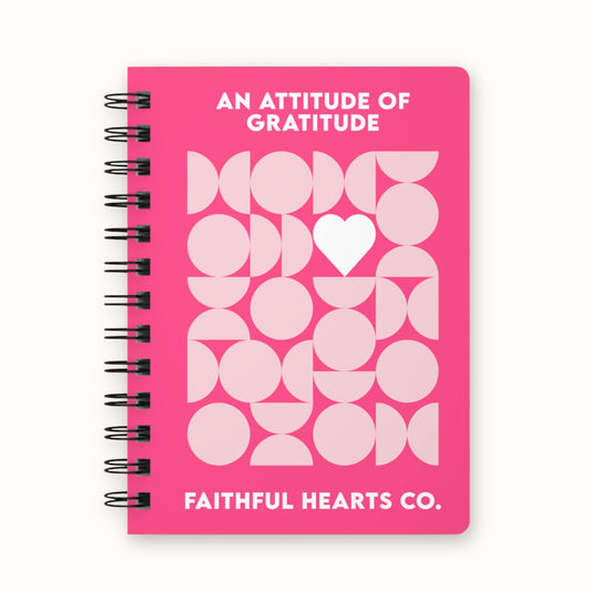 A5 gratitude and manifestation journal for women with pink geometric heart design on the cover, titled an attitude of gratitude