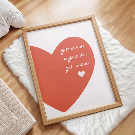 Framed artwork with a red heart and the bible verse 'Grace upon grace'