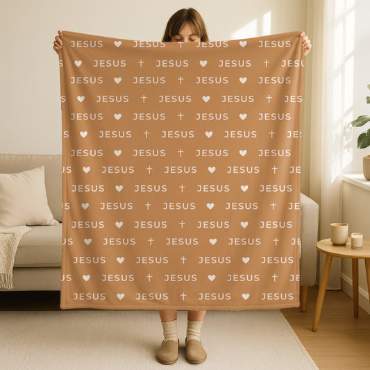 Jesus name blanket in warm tan beige with repeating Jesus text pattern, small hearts and crosses in cream white, minimalist Christian home decor throw blanket