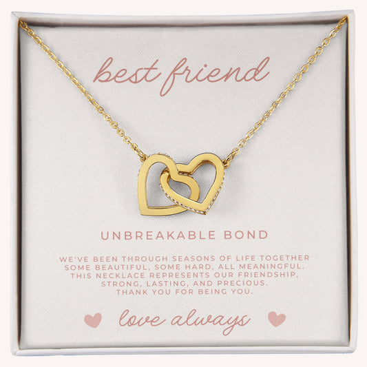 Gold necklace with interlocking hearts in a box labeled 'best friend' and 'unbreakable bond'.