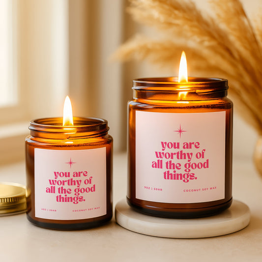 You are worthy of all the good things faith candle with pink label and star design in amber glass jar