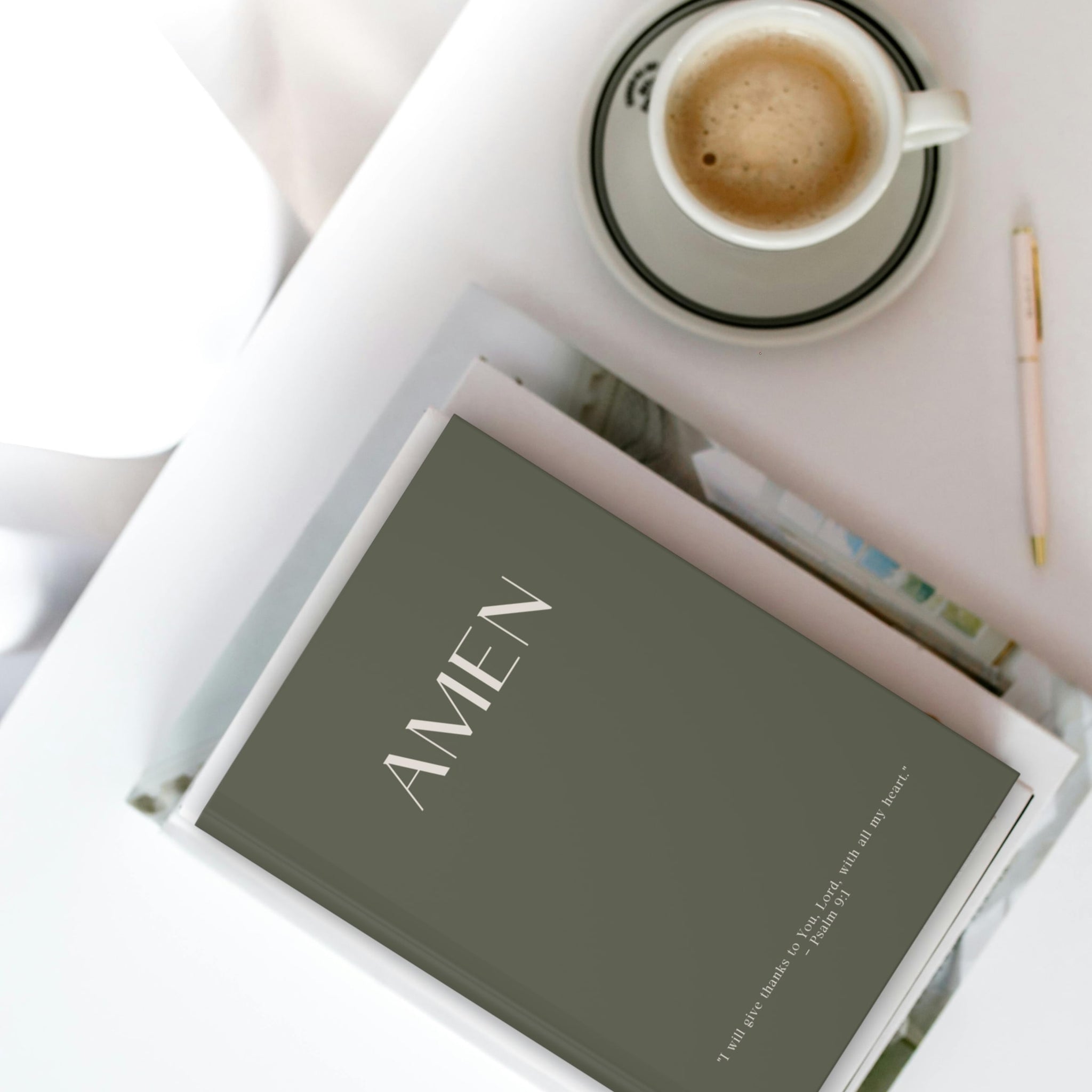 Olive green faith journal resting ontop of a stack of other books on a table, capturing luxurious matte finish and thoughtful design details