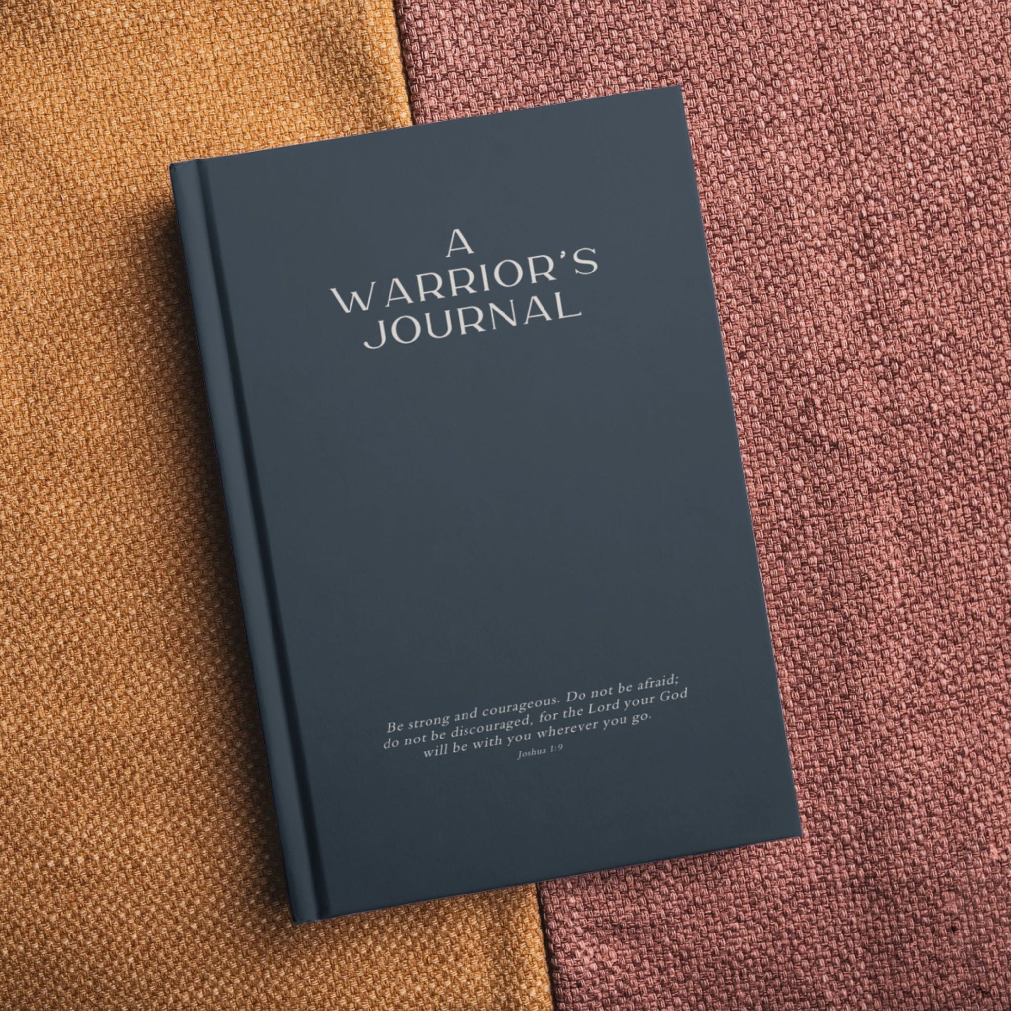 Navy blue men's journal with 'A Warrior's Journal' and Joshua 1:9 scripture, showcasing bold masculine design