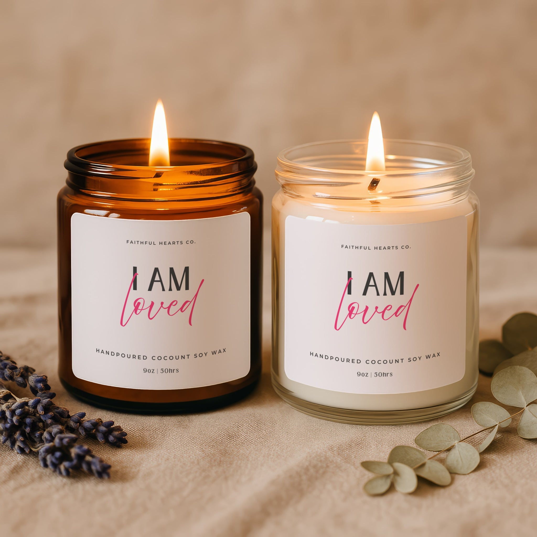 Two lit candles with 'I AM loved' labels with pink text