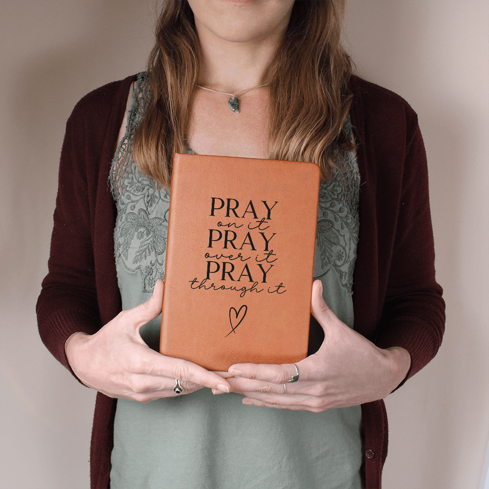 Close-up of brown leather journal with inspirational words on the cover.
