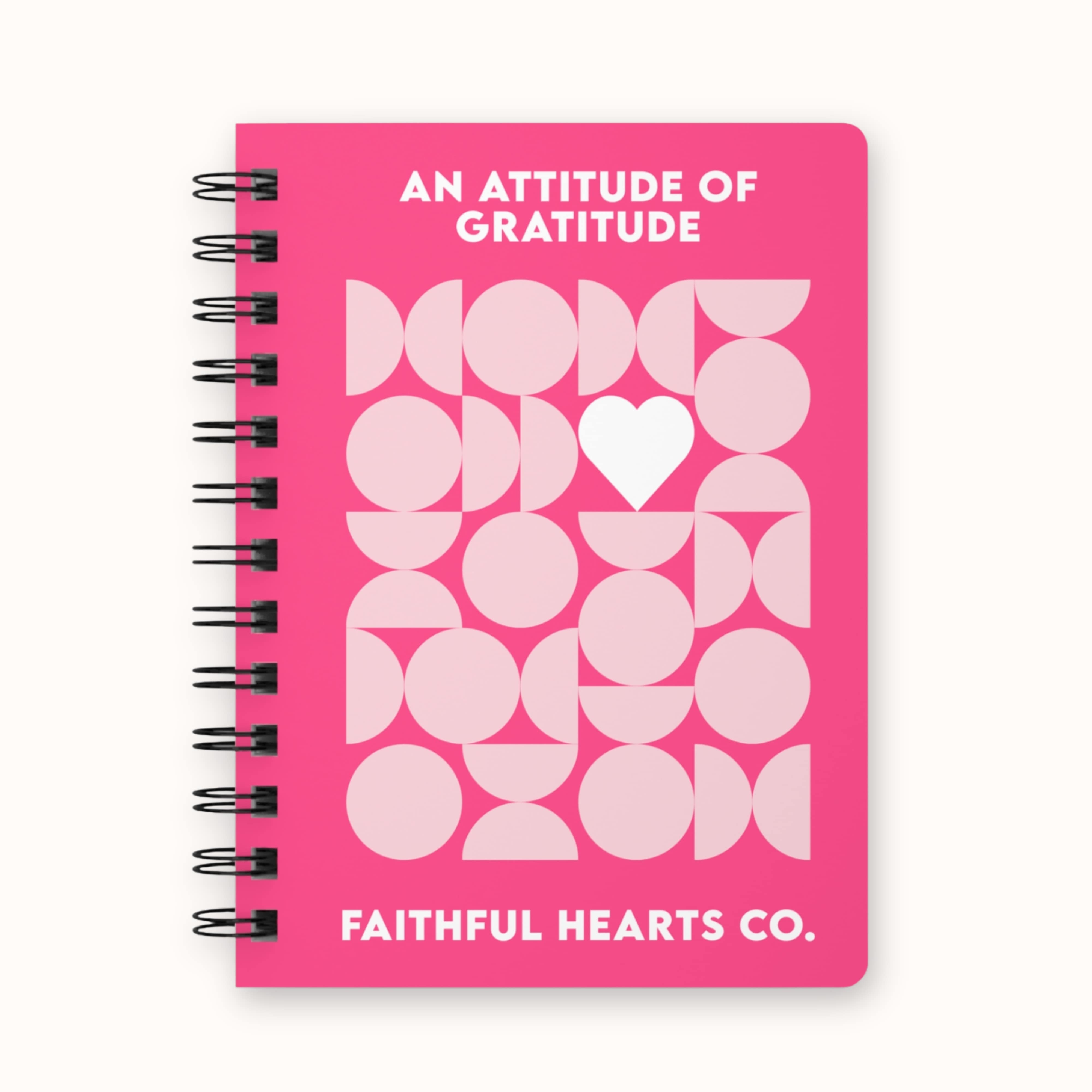 A5 gratitude and manifestation journal for women with pink geometric heart design on the cover, titled an attitude of gratitude