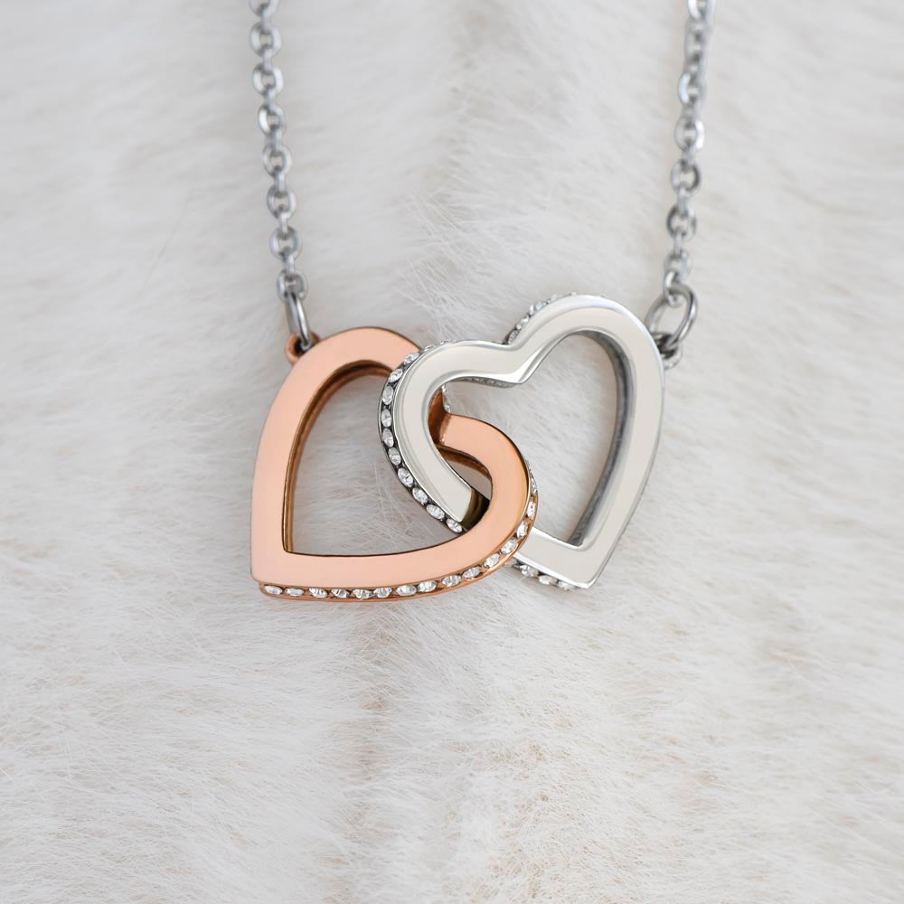close up of stainless steel and rose gold connected hearts necklace