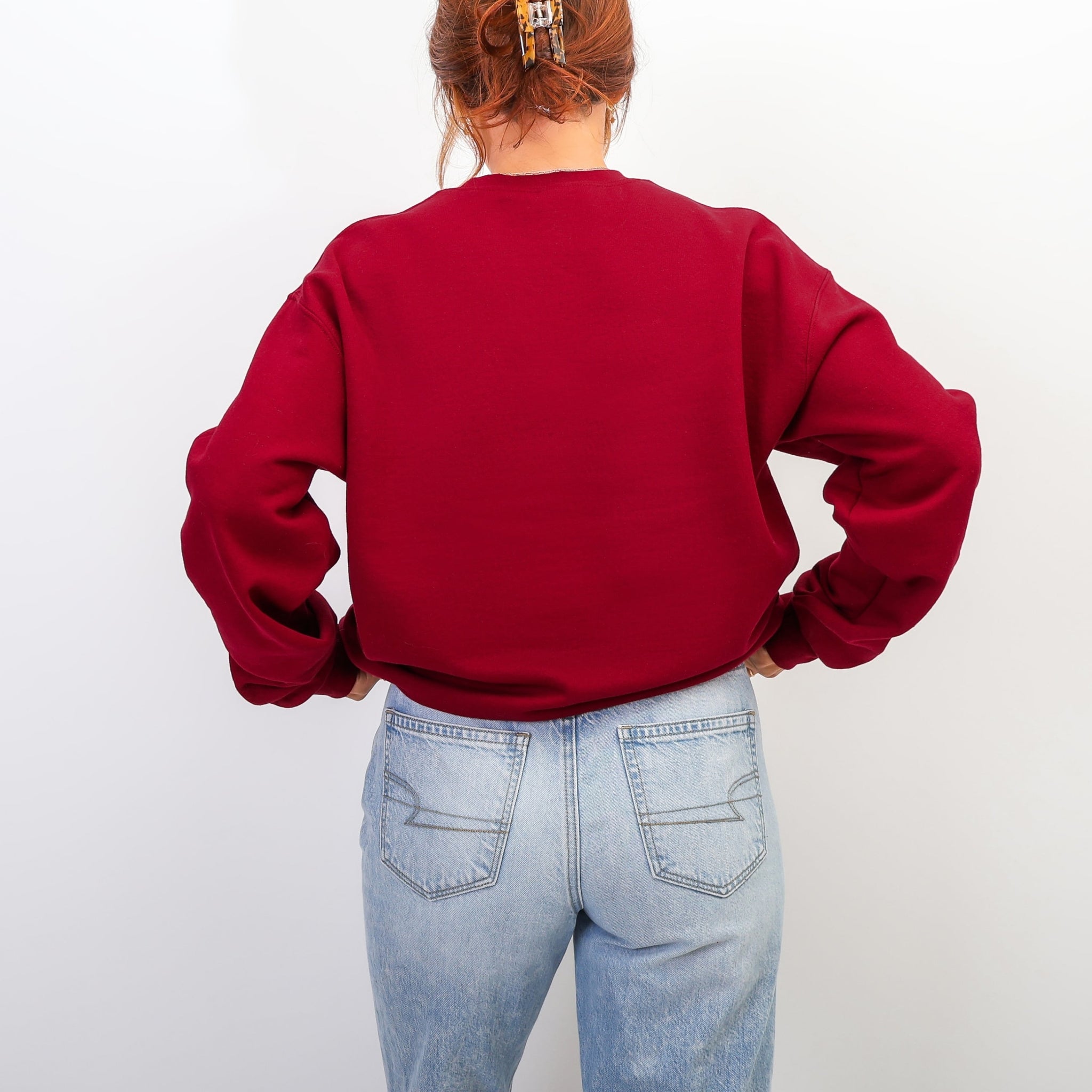 Back view of cardinal red Be The Reason sweatshirt with pink lettering - oversized inspirational crewneck for women