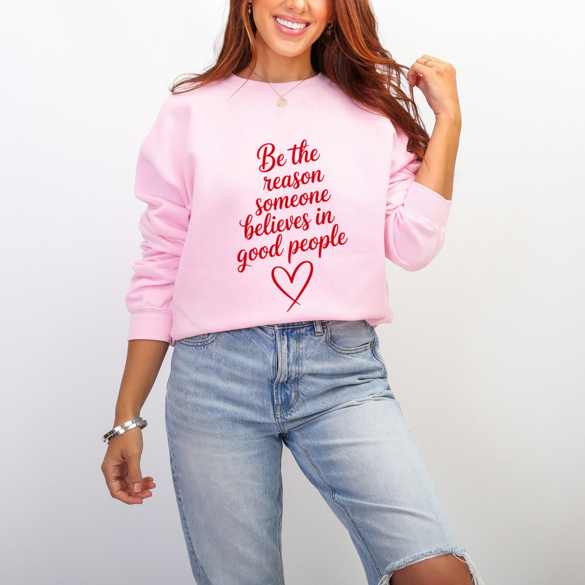 Woman wearing pink Be The Reason Someone Believes In Good People sweatshirt with jeans - inspirational kindness crewneck for women
