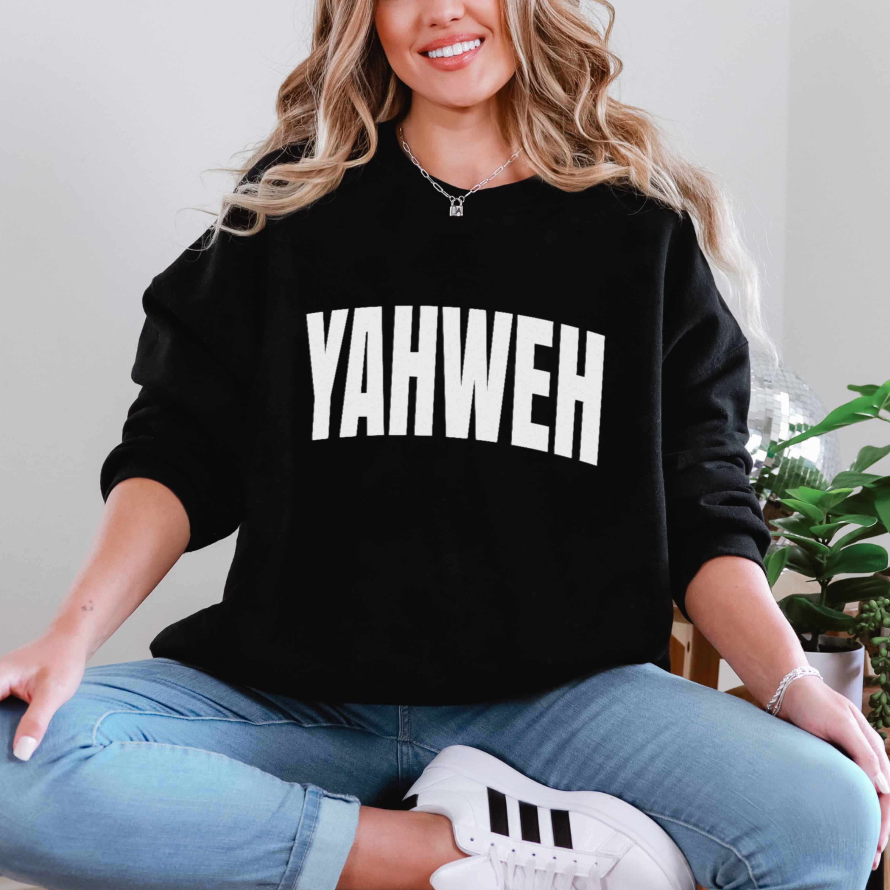 Woman wearing oversized black YAHWEH sweatshirt with white lettering - bold Christian Hebrew name of God crewneck for women