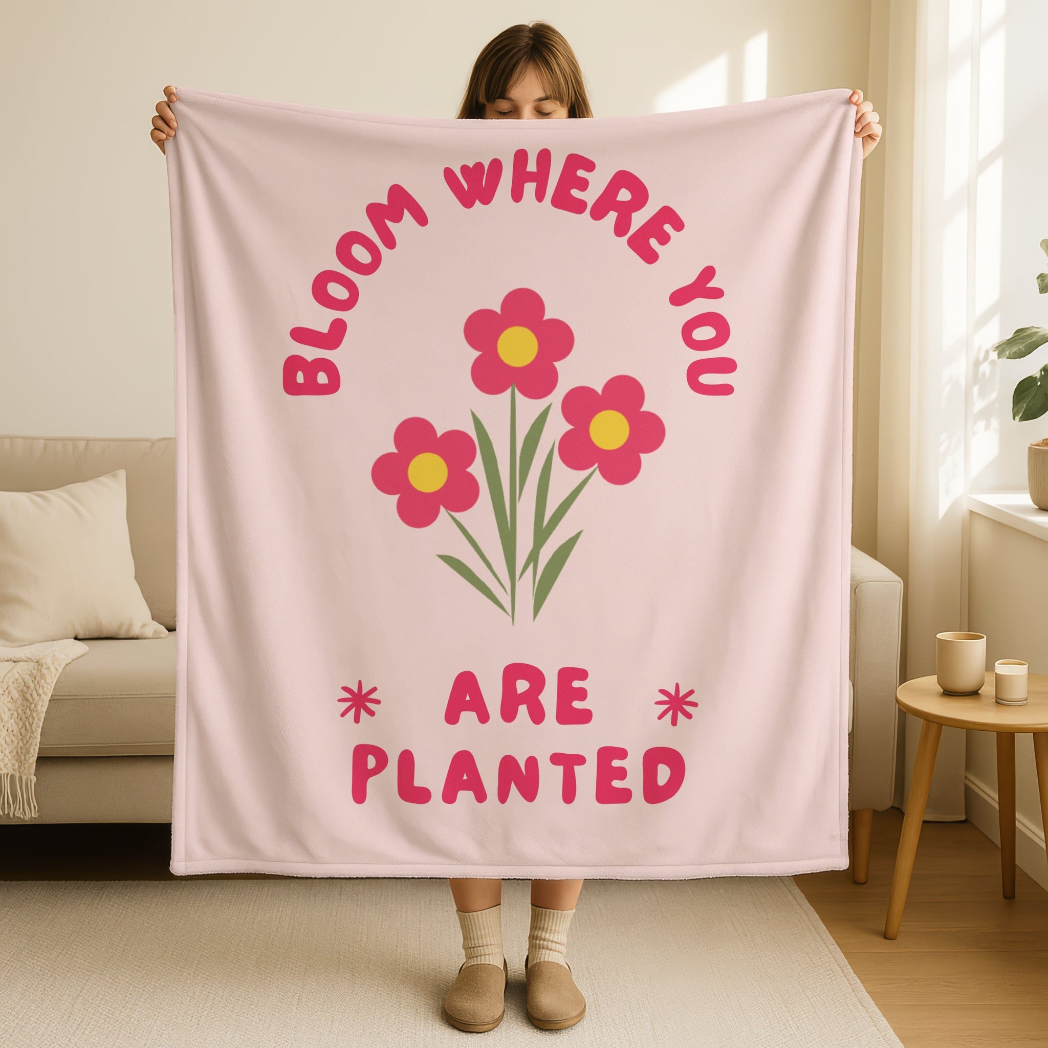 Bloom where you are planted blanket in soft blush pink with bright pink flowers and yellow centers, green stems, retro groovy text in hot pink, encouraging Christian throw blanket