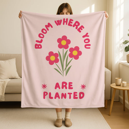 Bloom where you are planted blanket in soft blush pink with bright pink flowers and yellow centers, green stems, retro groovy text in hot pink, encouraging Christian throw blanket
