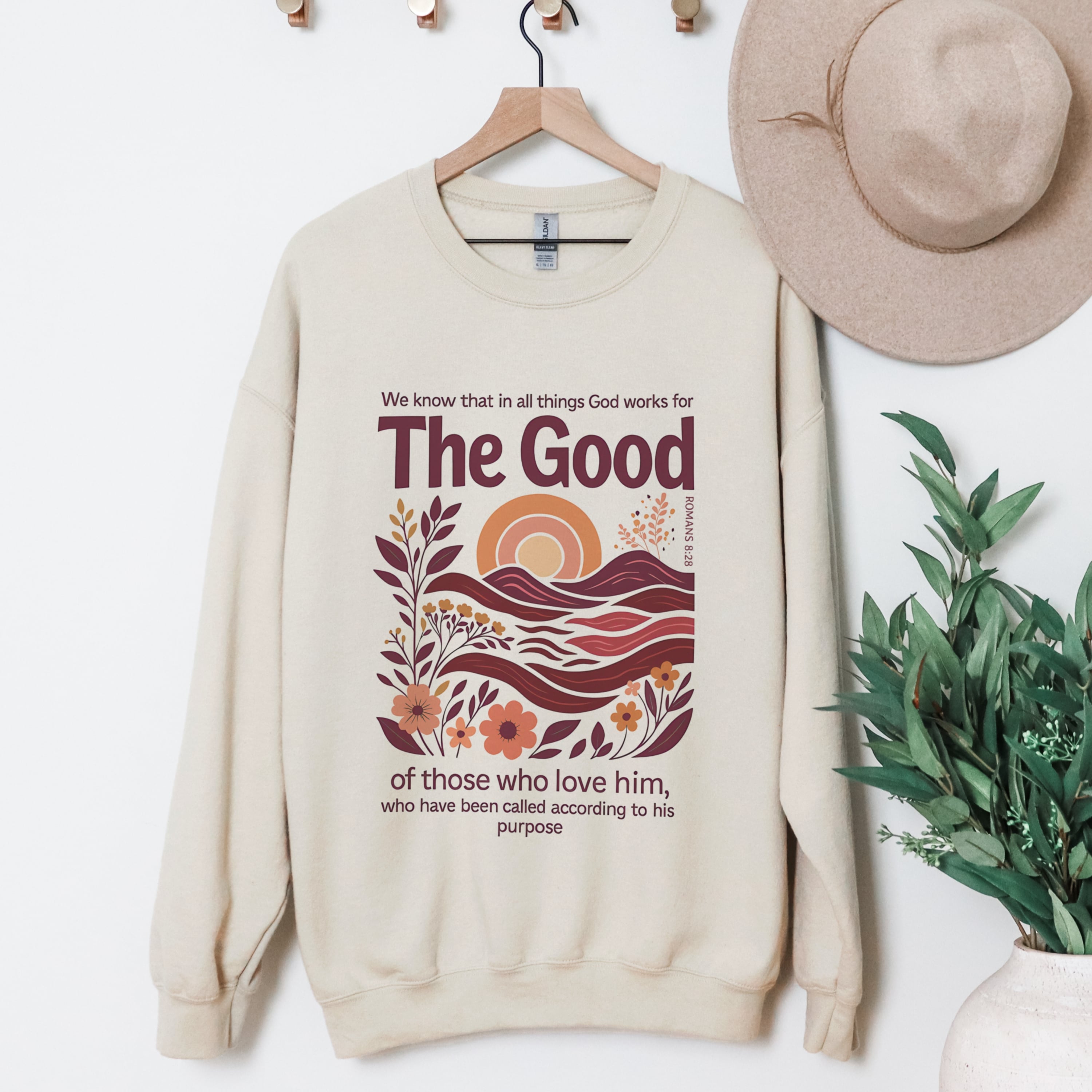 God Works For The Good Romans 8:28 beige sweatshirt hanging display - boho landscape Christian crewneck clothing