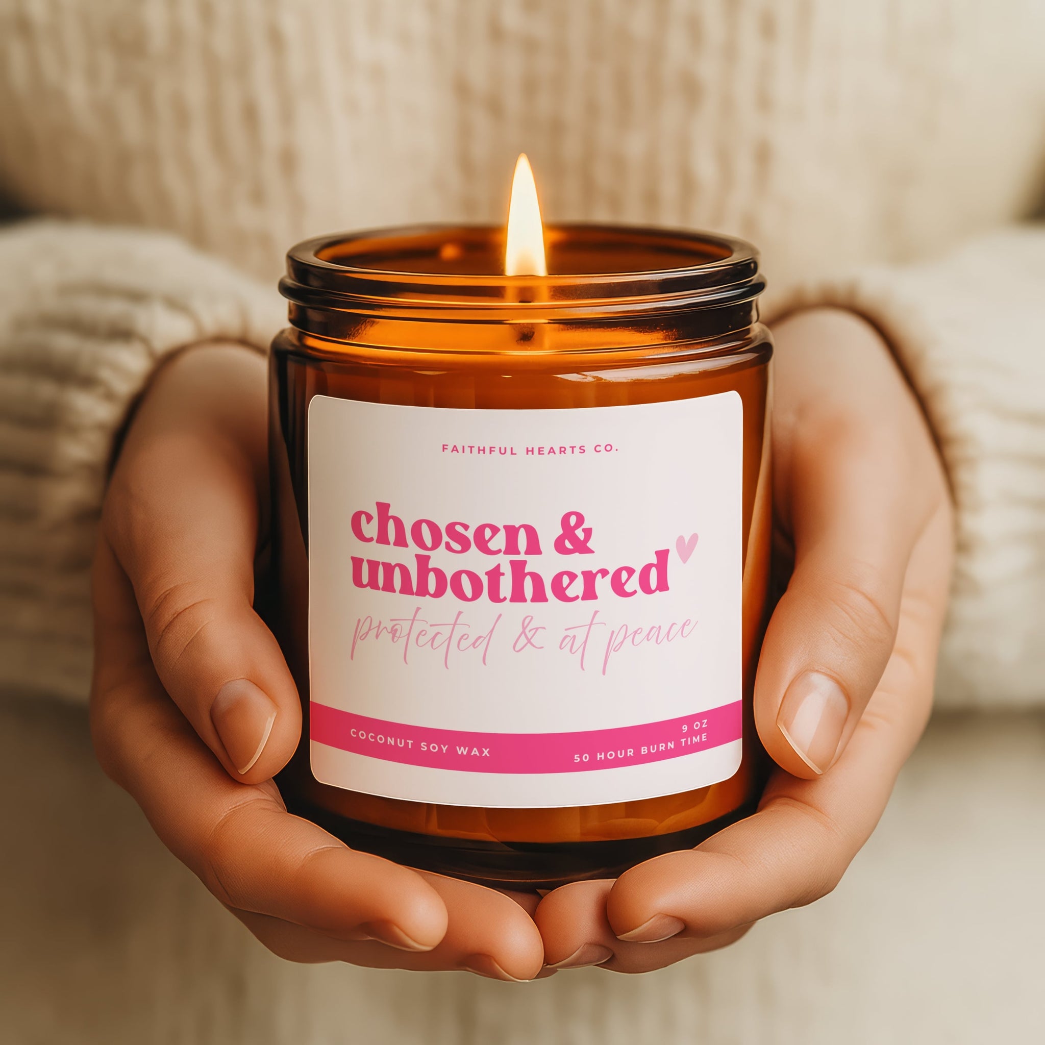 Candle in an amber jar with a 'chosen & unbothered' label held in hands.