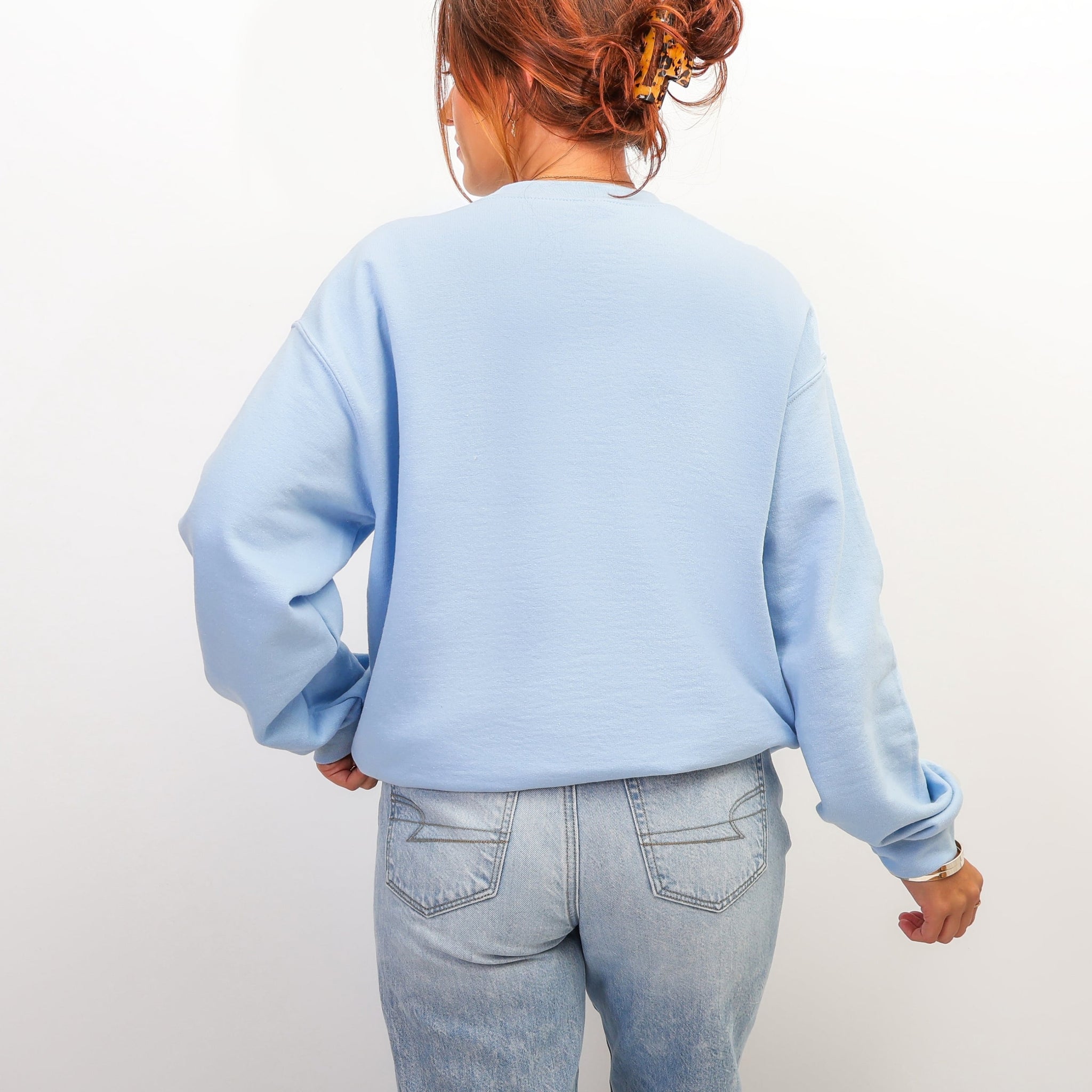 Back view of light blue Jesus lemonade sweatshirt at beach - oversized Christian crewneck for women