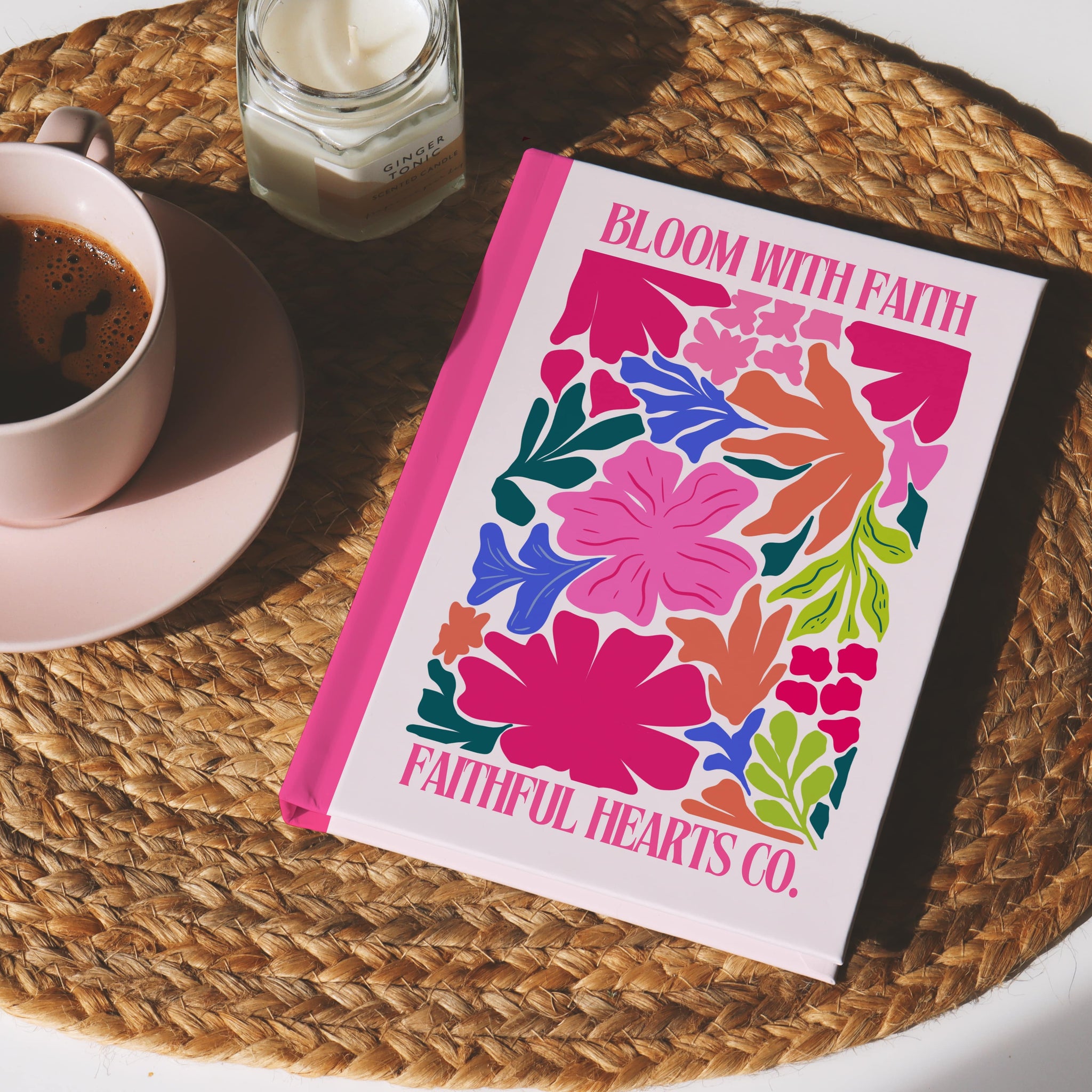 Vibrant flower-patterned Christian notebook with pink spine and “Bloom With Faith” text