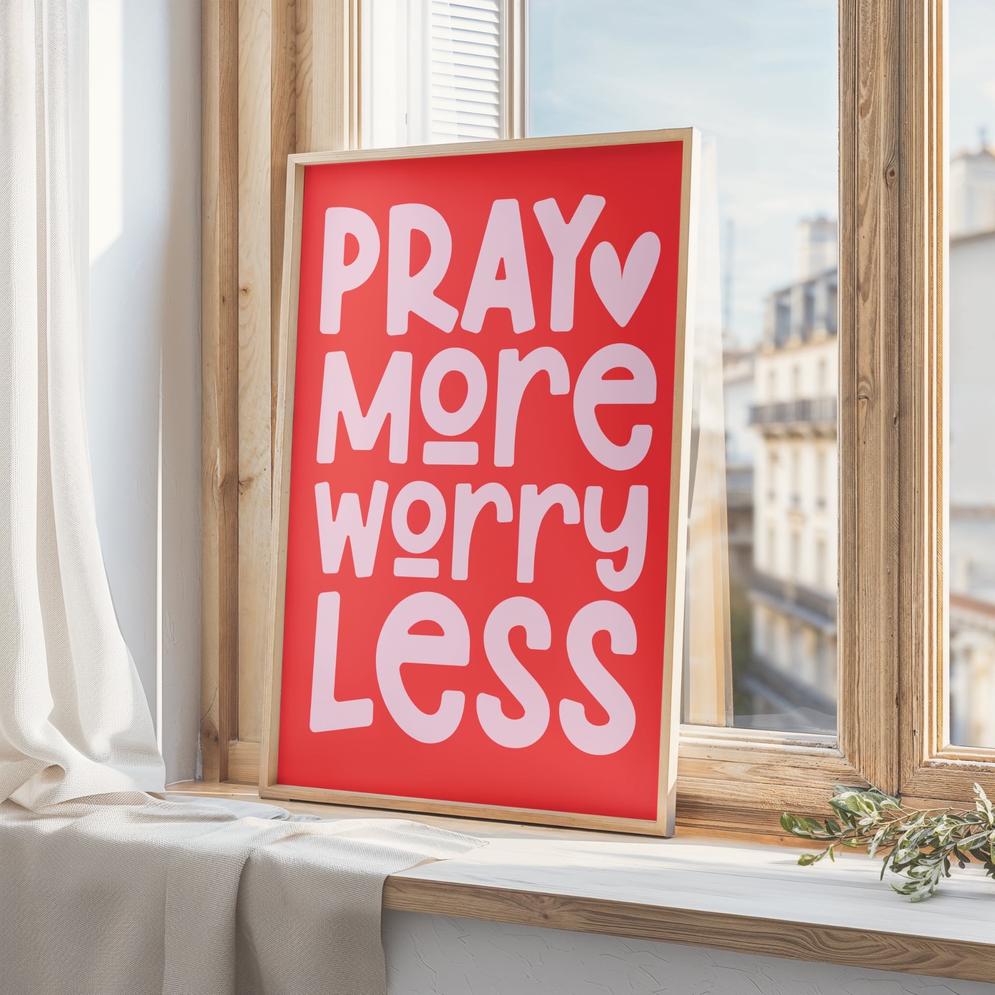 Framed poster with 'Pray More Worry Less' text on a windowsill.