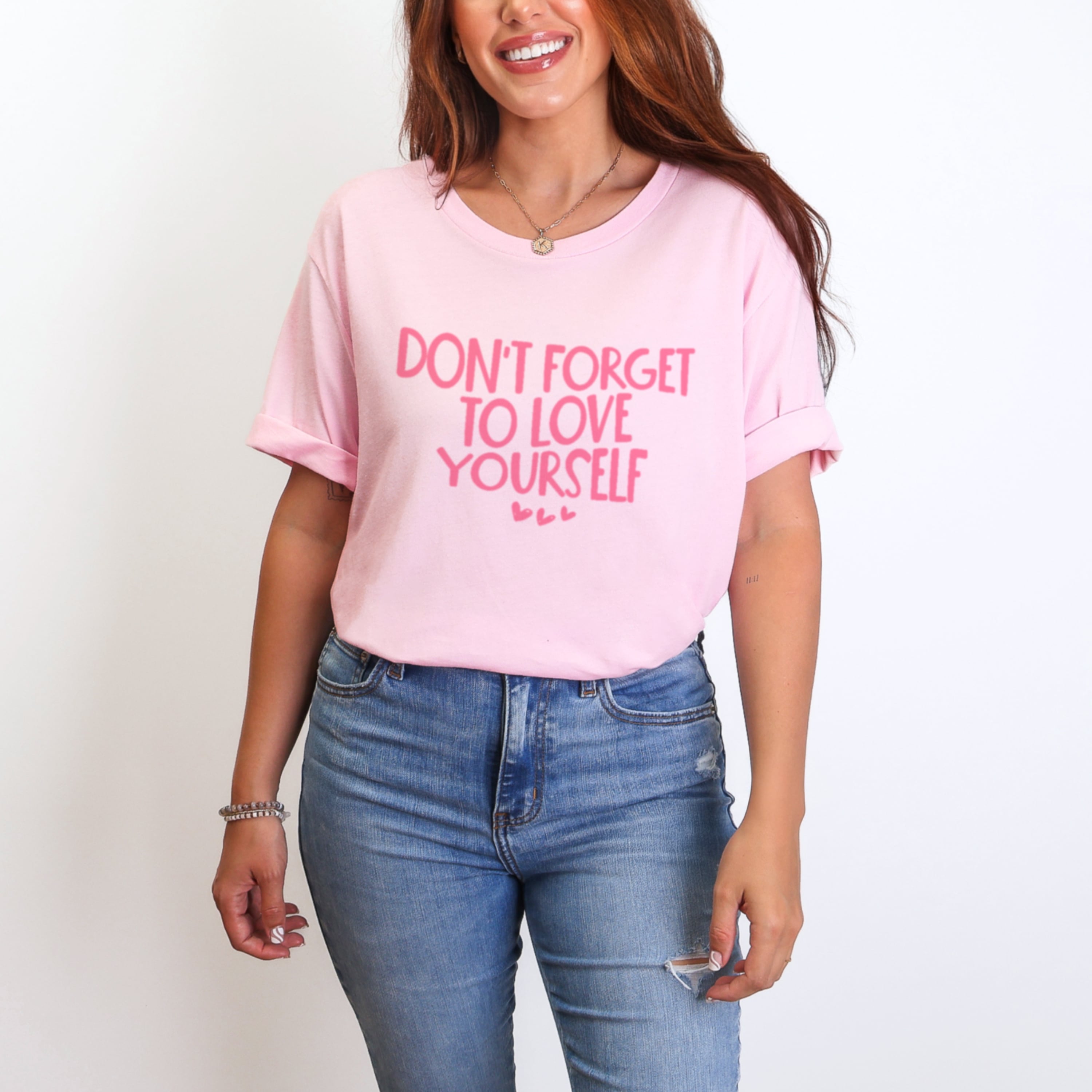 Woman wearing light pink Don't Forget To Love Yourself tshirt with hot pink lettering, self-love reminder graphic tee