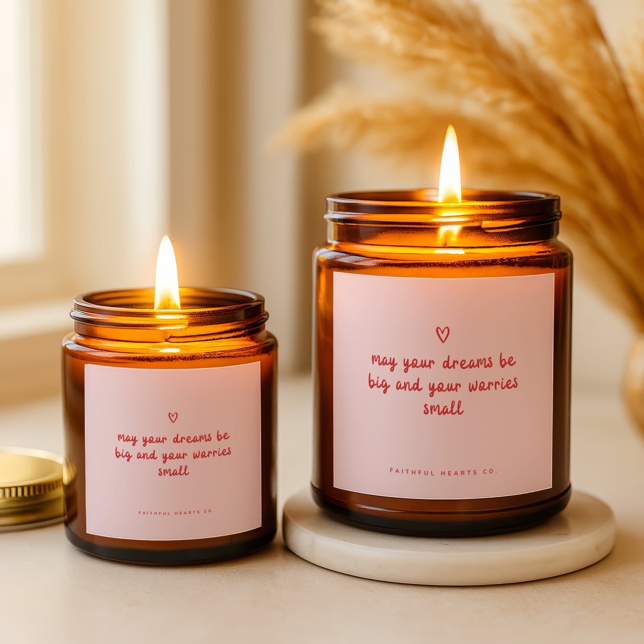 May your dreams be big and your worries small faith candle with pink label and heart design in amber glass jar