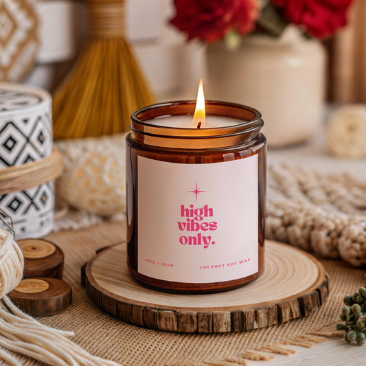 High Vibes Only candle in amber glass jar with bright pink label, handmade coconut apricot wax affirmation candle gift for women who love positivity, manifestation, and spiritual wellness.