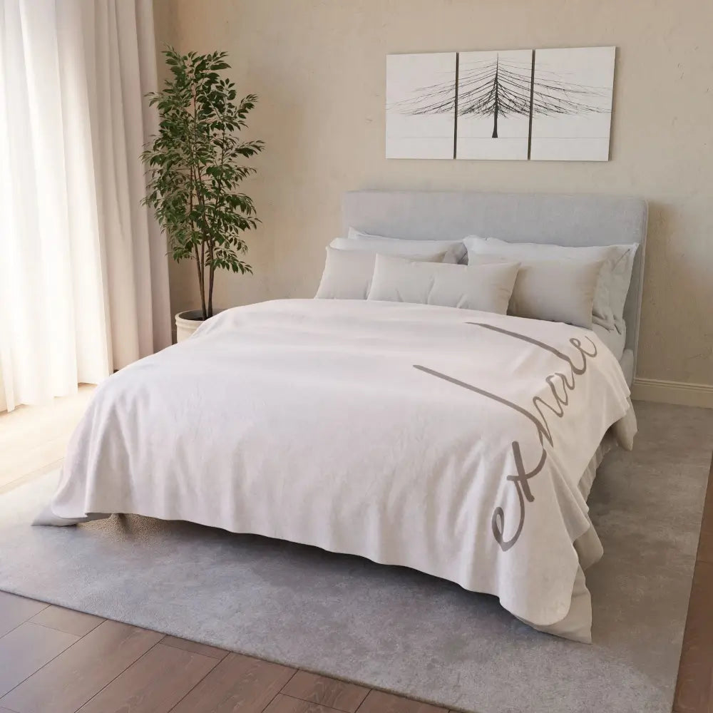 Soft life blanket in warm sand tones with gentle affirmation of exhale, covering a full queen size bed