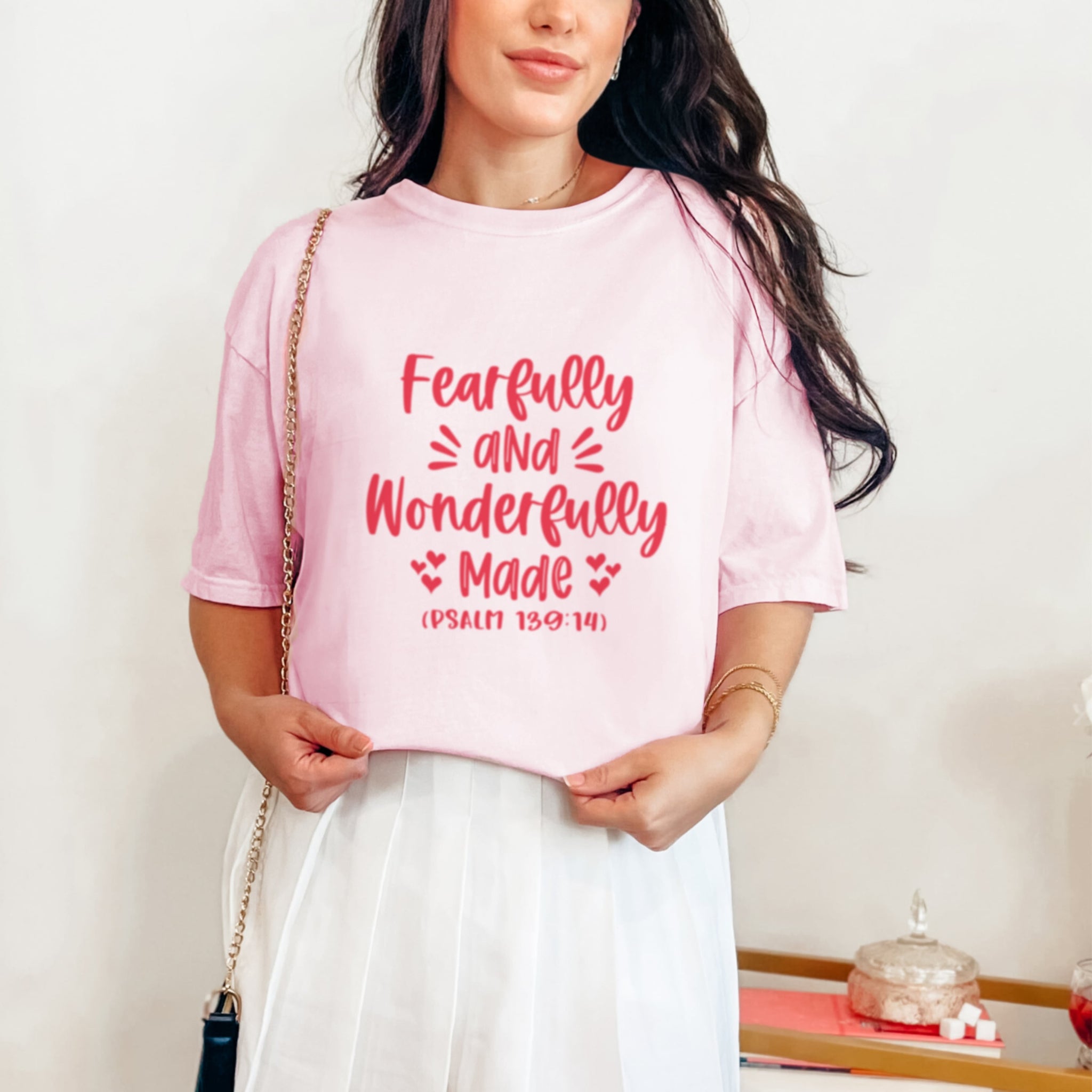 Woman wearing light pink Fearfully and Wonderfully Made tshirt with Psalm 139:14, blossom colored faith-based graphic tee
