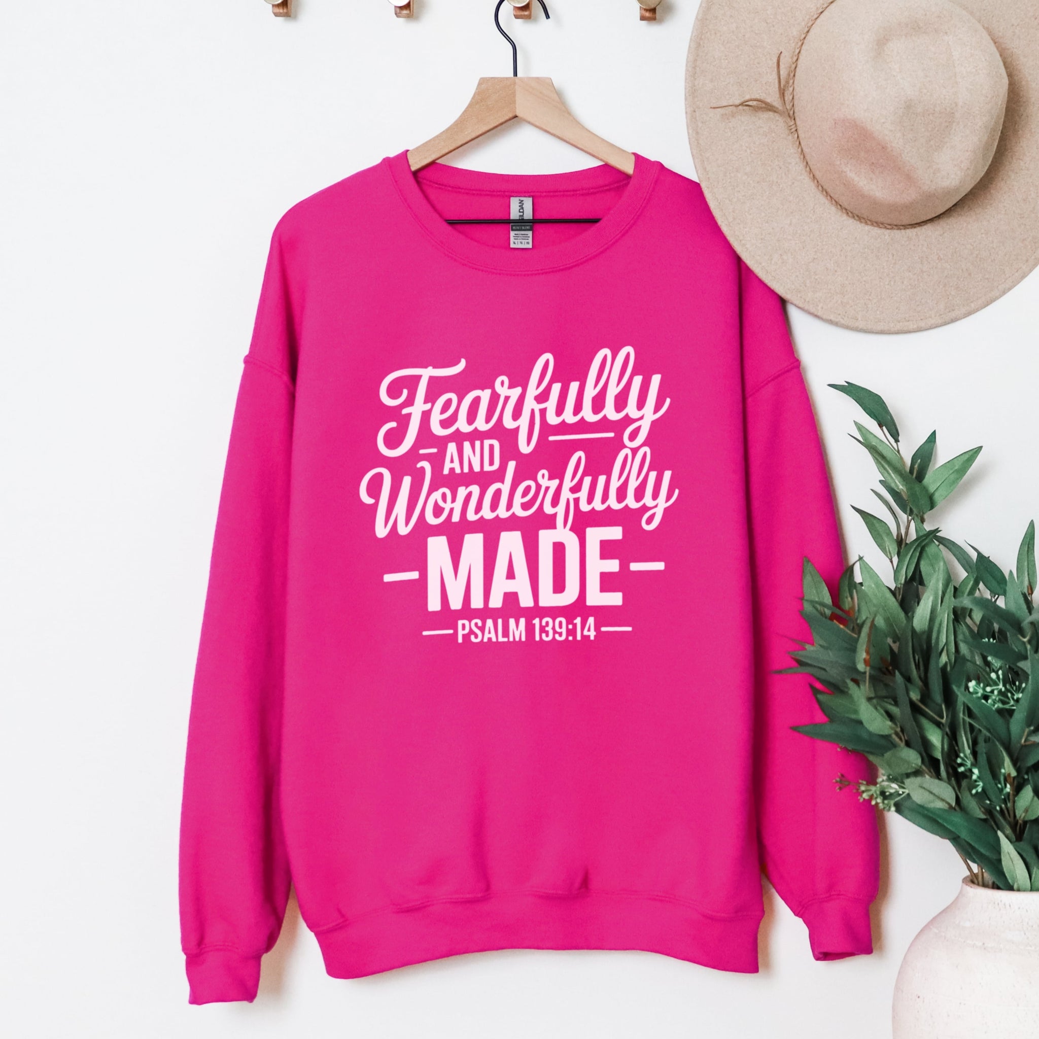 Hot pink Fearfully And Wonderfully Made Psalm 139:14 sweatshirt hanging display - scripture Christian crewneck clothing