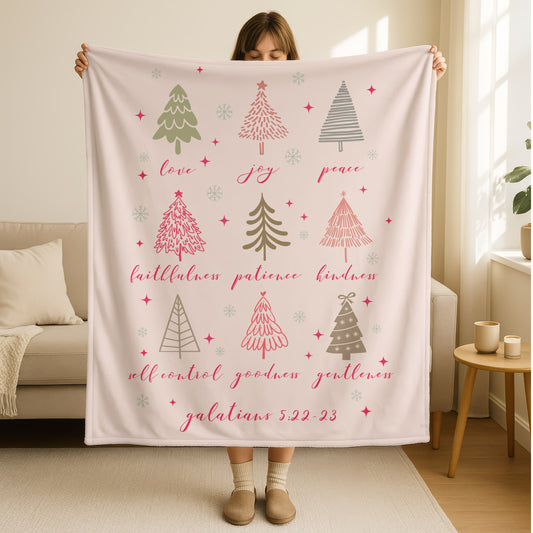 Fruit of the Spirit Christmas blanket in soft pink with whimsical Christmas trees and Galatians 5:22-23 scripture featuring love, joy, peace, patience, kindness, goodness, faithfulness, gentleness, and self-control