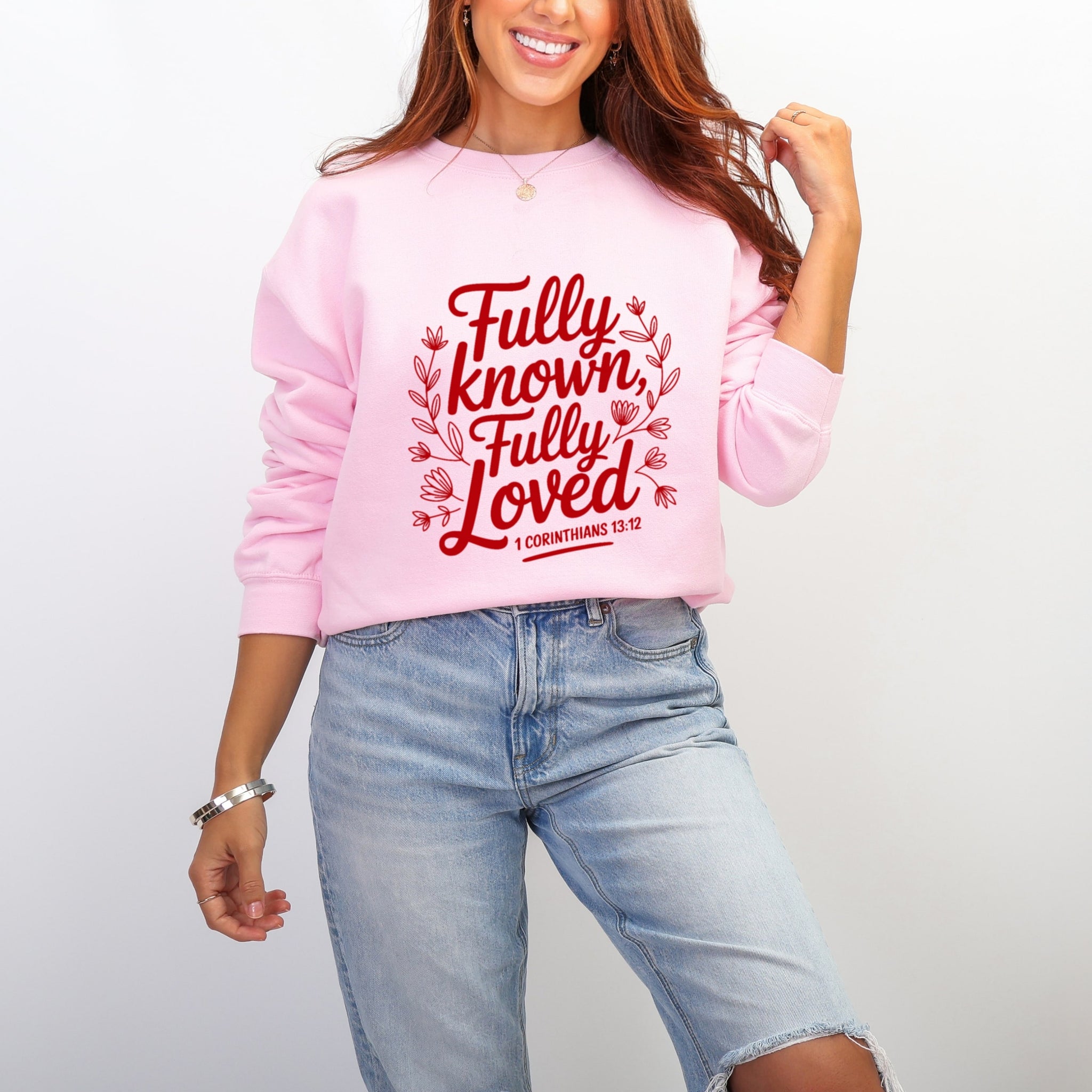 Woman wearing light pink Fully Known Fully Loved sweatshirt with 1 Corinthians 13:12 scripture - Christian crewneck for women