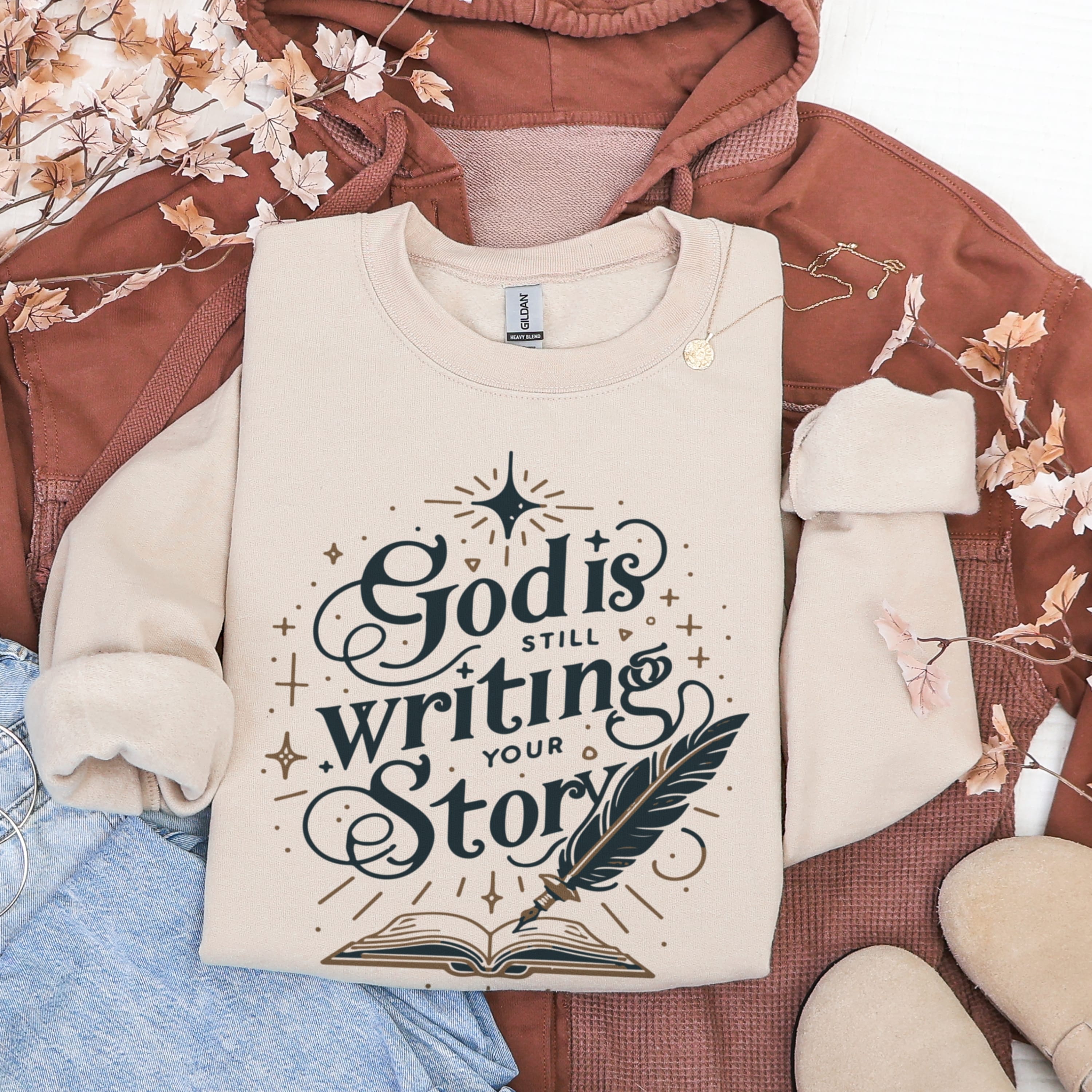Sand beige God Is Still Writing Your Story sweatshirt flat lay with autumn decor - aesthetic Christian faith apparel for women