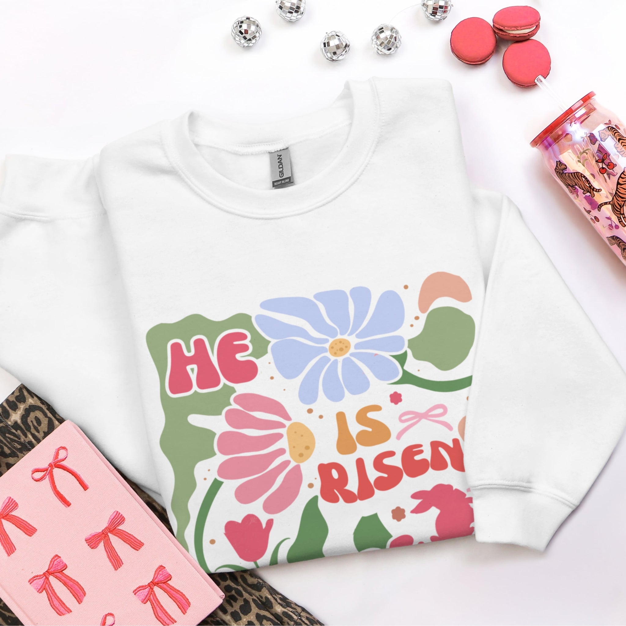 White He Is Risen sweatshirt with vintage floral design flat lay - groovy Christian faith apparel for women