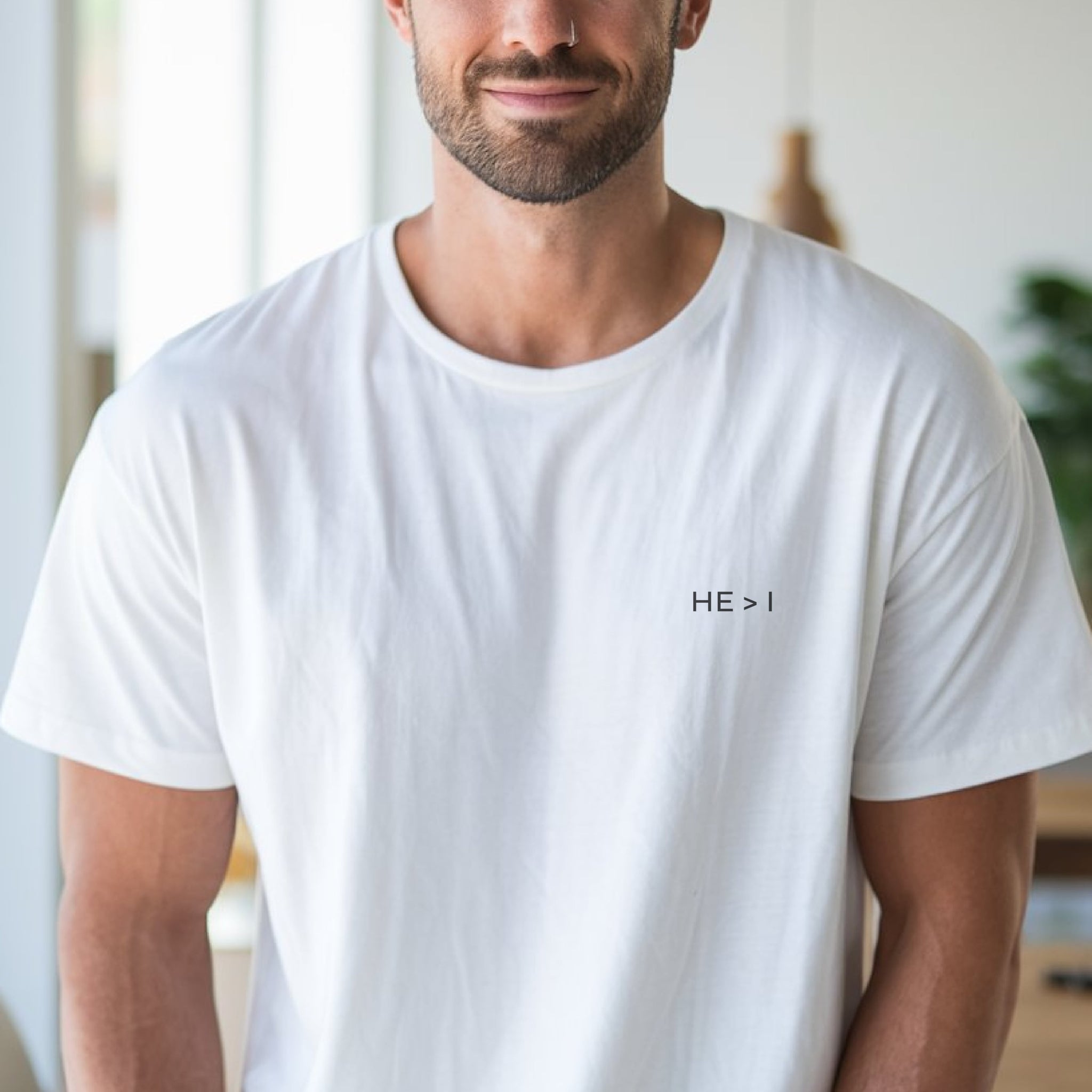 Person wearing white, minimalist He > I Christian T-Shirt.