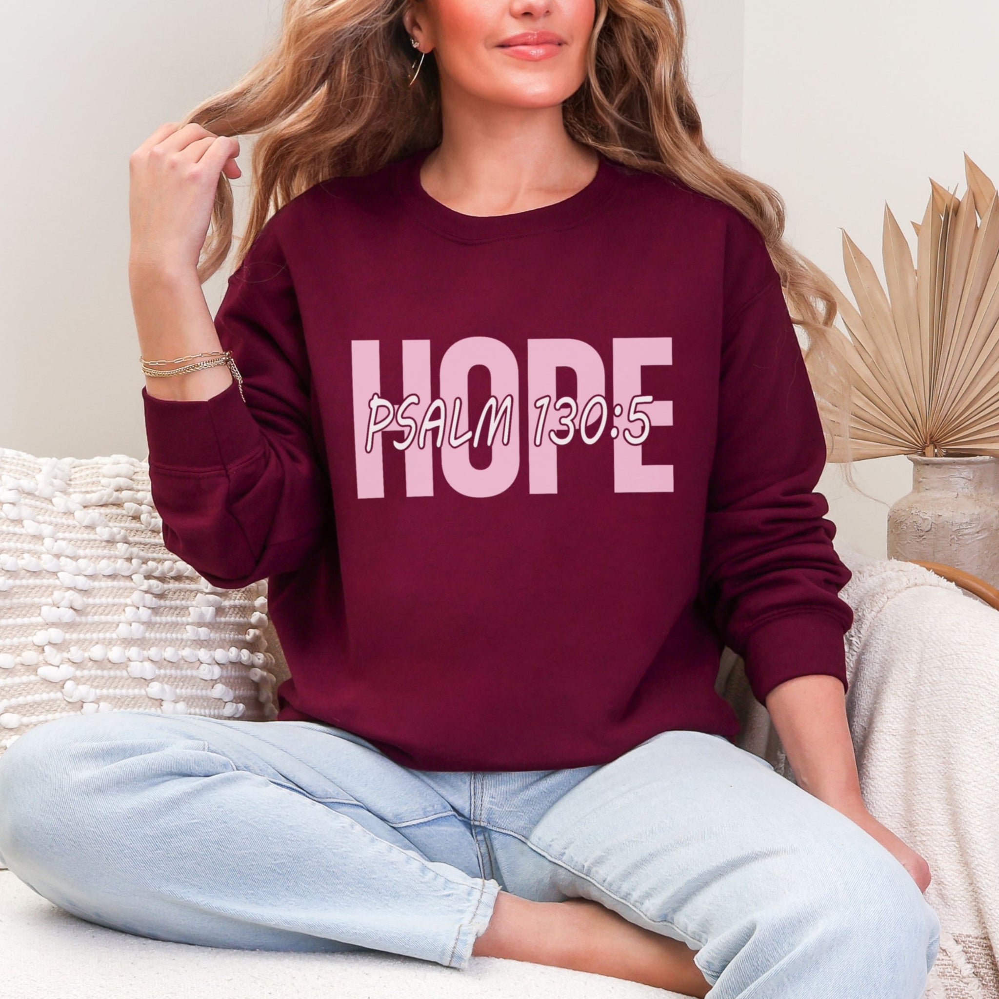 Woman wearing maroon Hope sweatshirt with Psalm 130:5 scripture and jeans - burgundy Christian crewneck for women