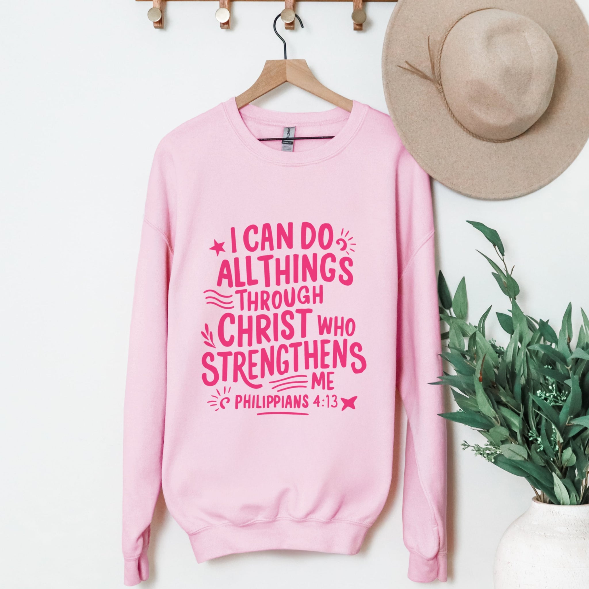Pink I Can Do All Things Through Christ crewneck sweatshirt hanging display - Philippians 4:13 Bible verse Christian clothing