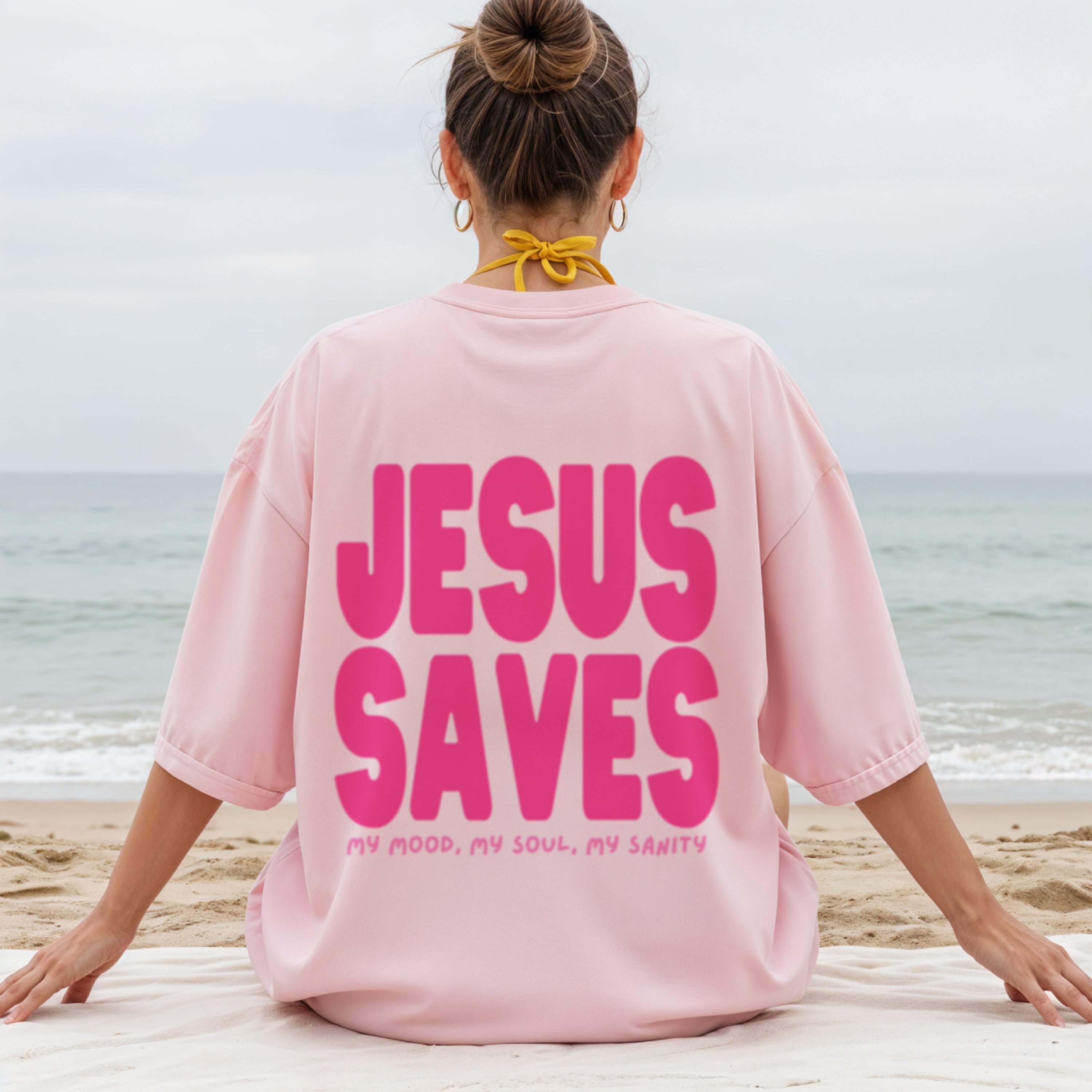 Woman wearing Jesus Saves pink t-shirt showing back design, girly Christian faith fashion for women