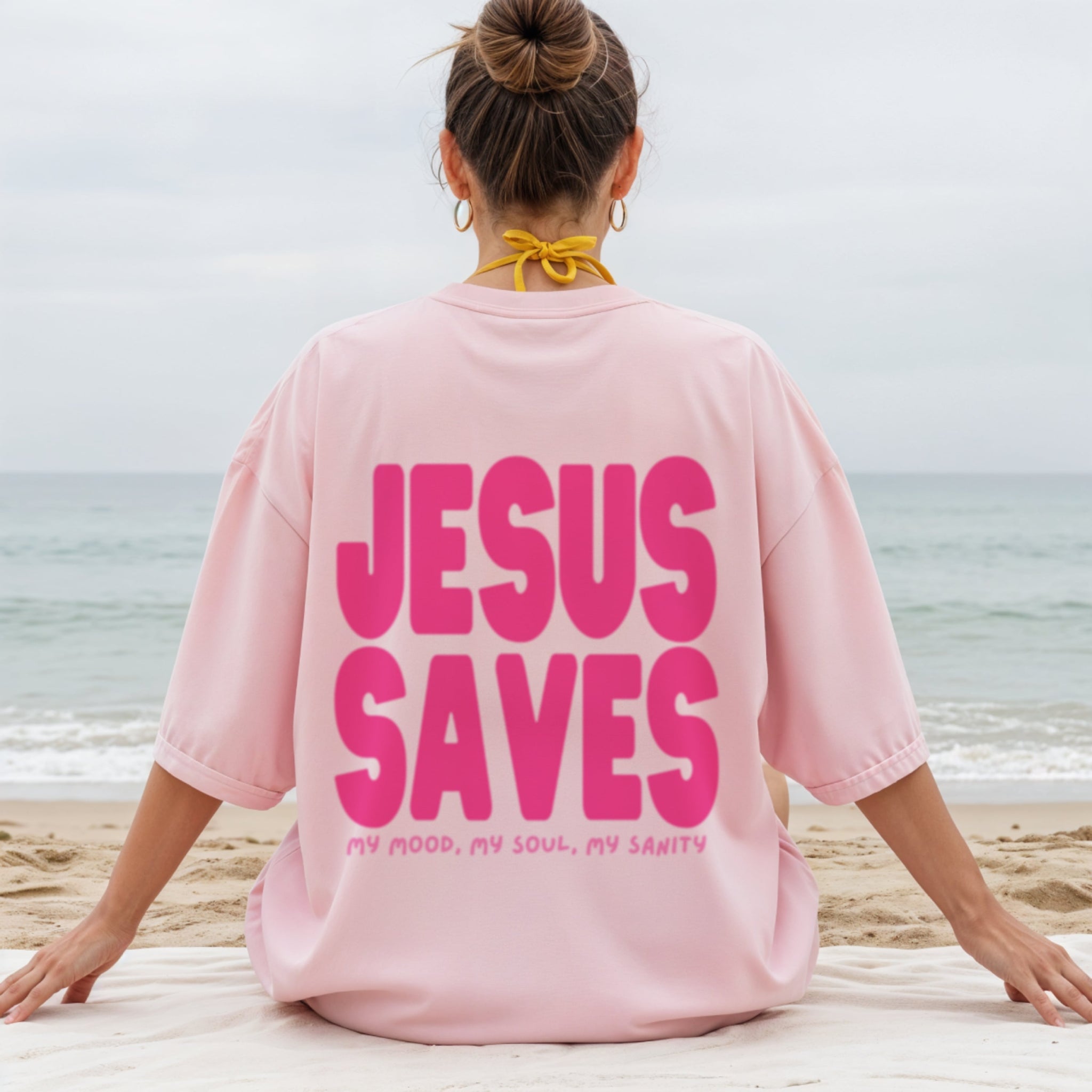 Woman wearing Jesus Saves pink t-shirt showing back design, girly Christian faith fashion for women