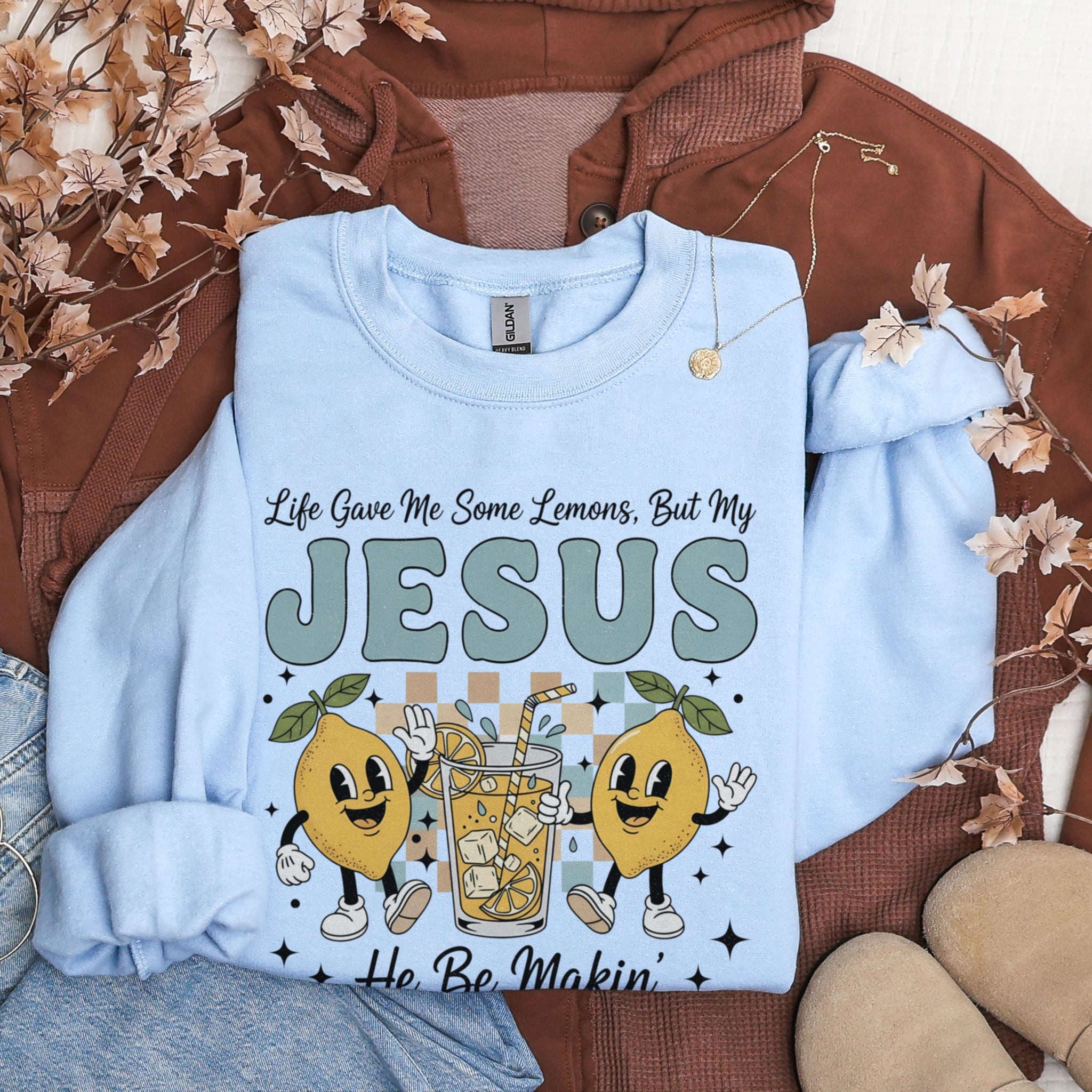 Light blue Life Gave Me Lemons Jesus sweatshirt flat lay with autumn decor - playful Christian faith apparel for women