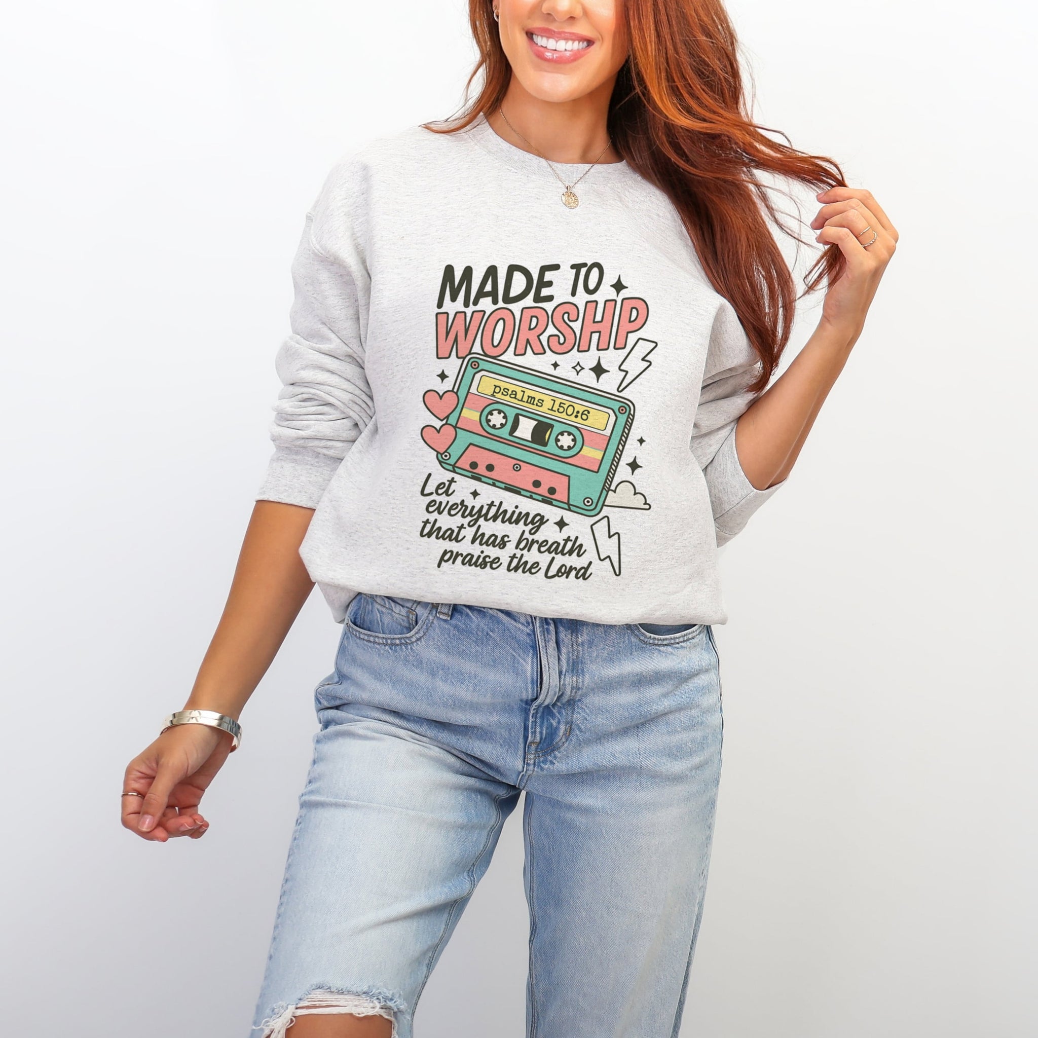 Woman wearing ash grey Made To Worship sweatshirt with retro cassette tape Psalm 150:6 design - fun Christian crewneck for women