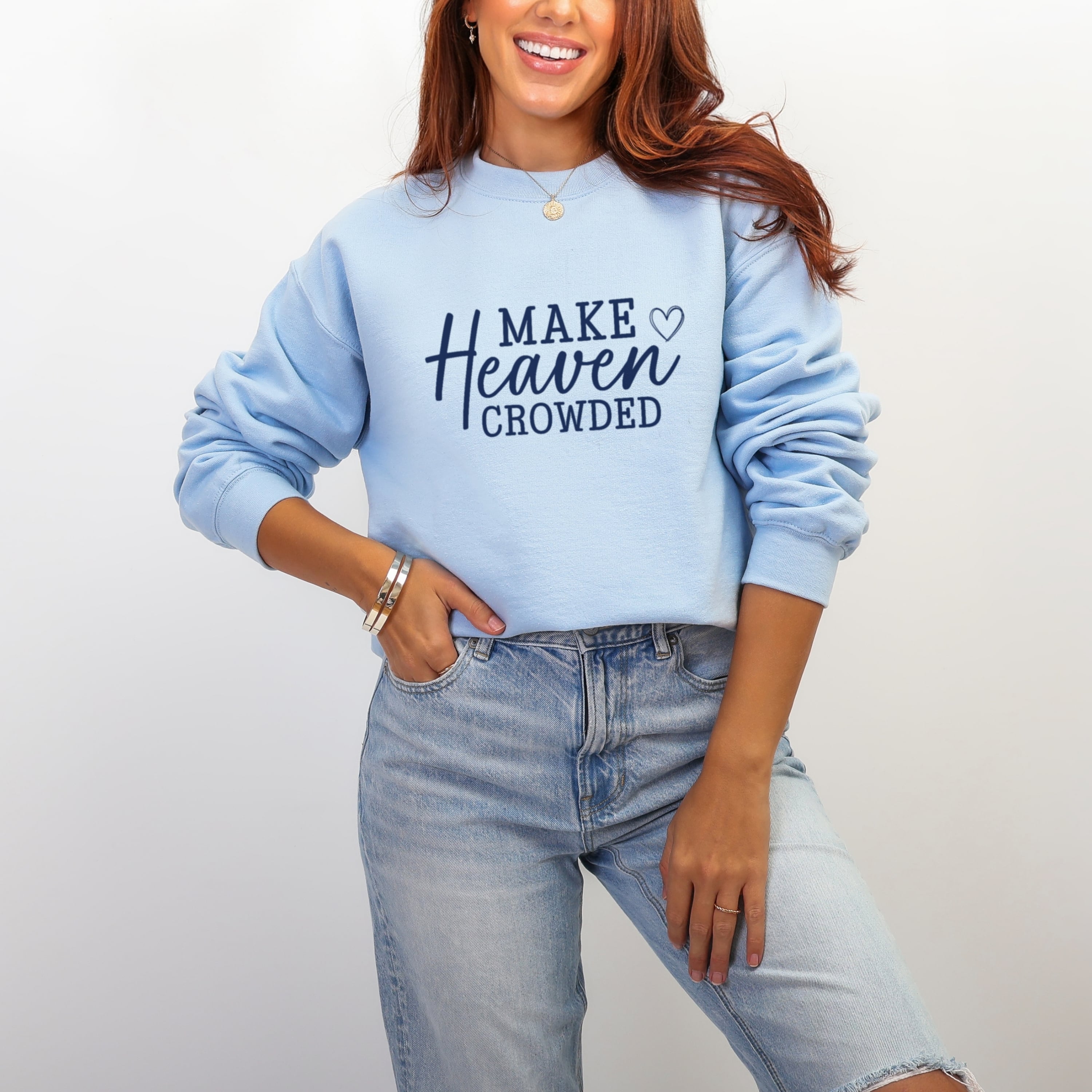 Woman wearing light blue Make Heaven Crowded sweatshirt - trendy Christian faith mission crewneck for women