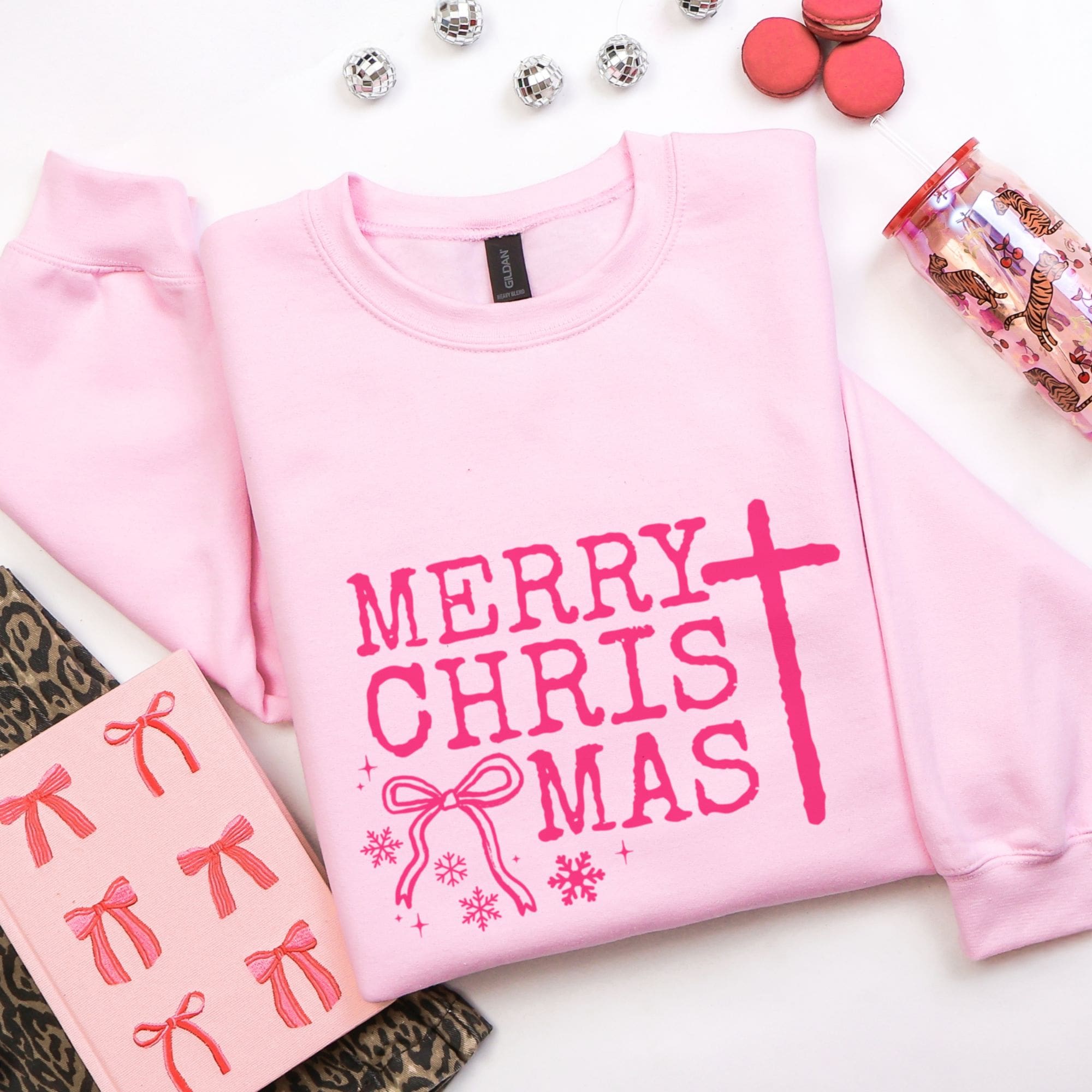 Pink sweatshirt with 'Merry Chris Mas' text on a white background