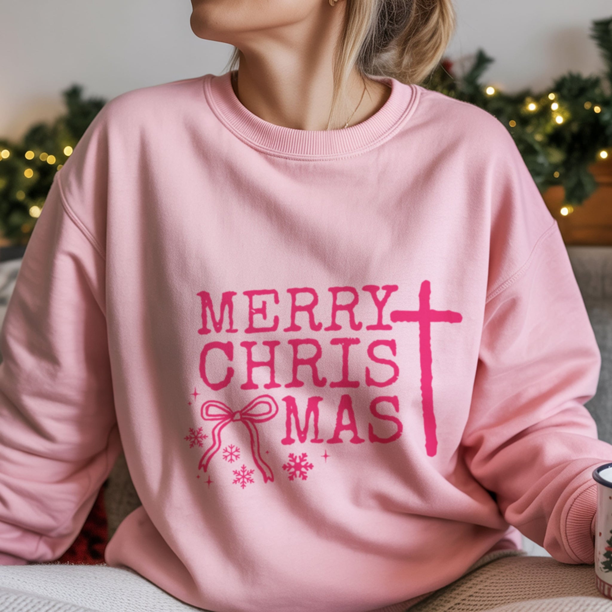 Merry ChrisTmas text with cross replacing T, bow and snowflake details on pink Christian holiday sweatshirt