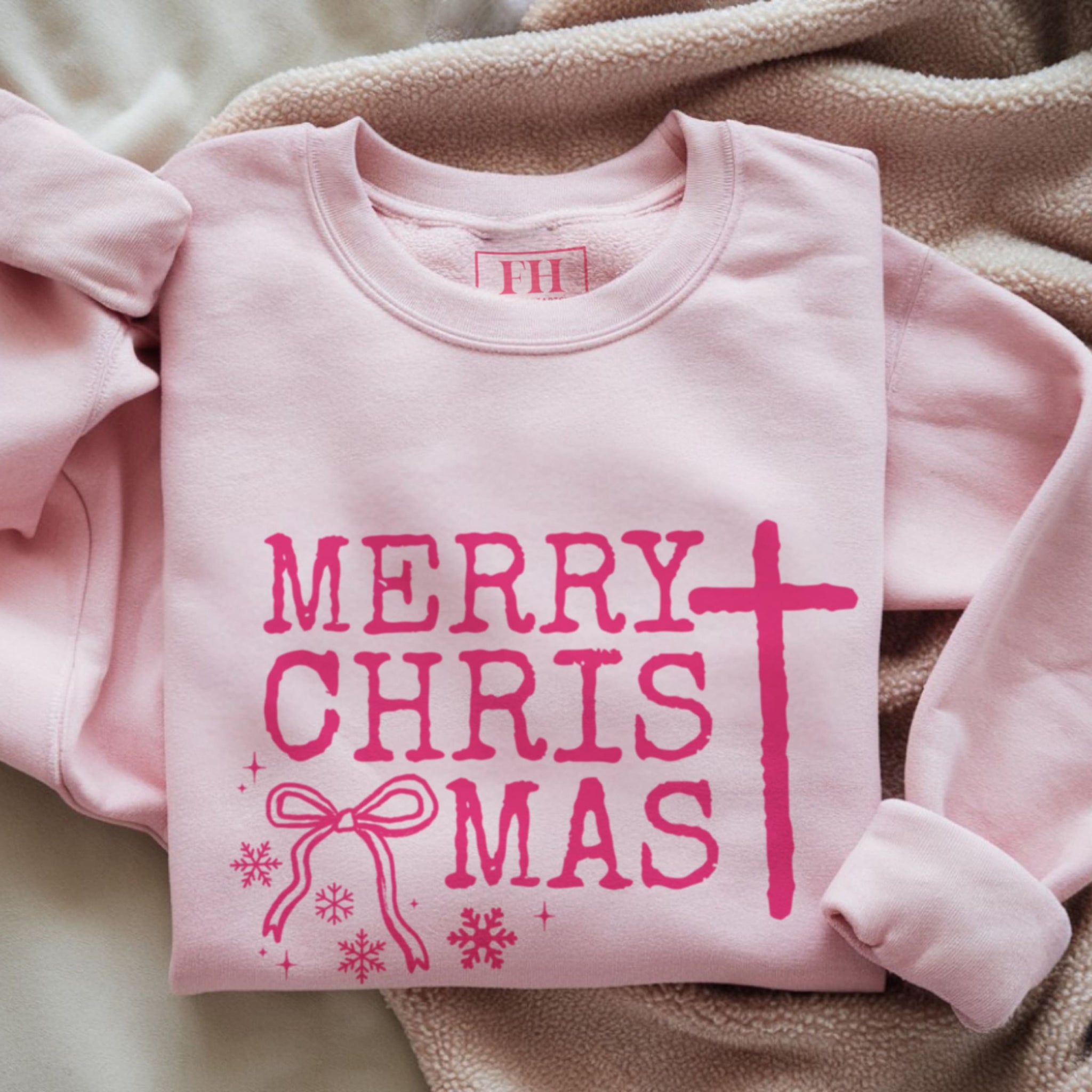 Merry ChrisTmas cross crewneck sweatshirt flat lay in pink, Christian holiday apparel by Faithful Hearts Co