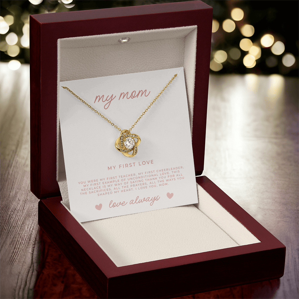 Gold love knot necklace on display inside luxury mahogany gift box with Christian message to mom