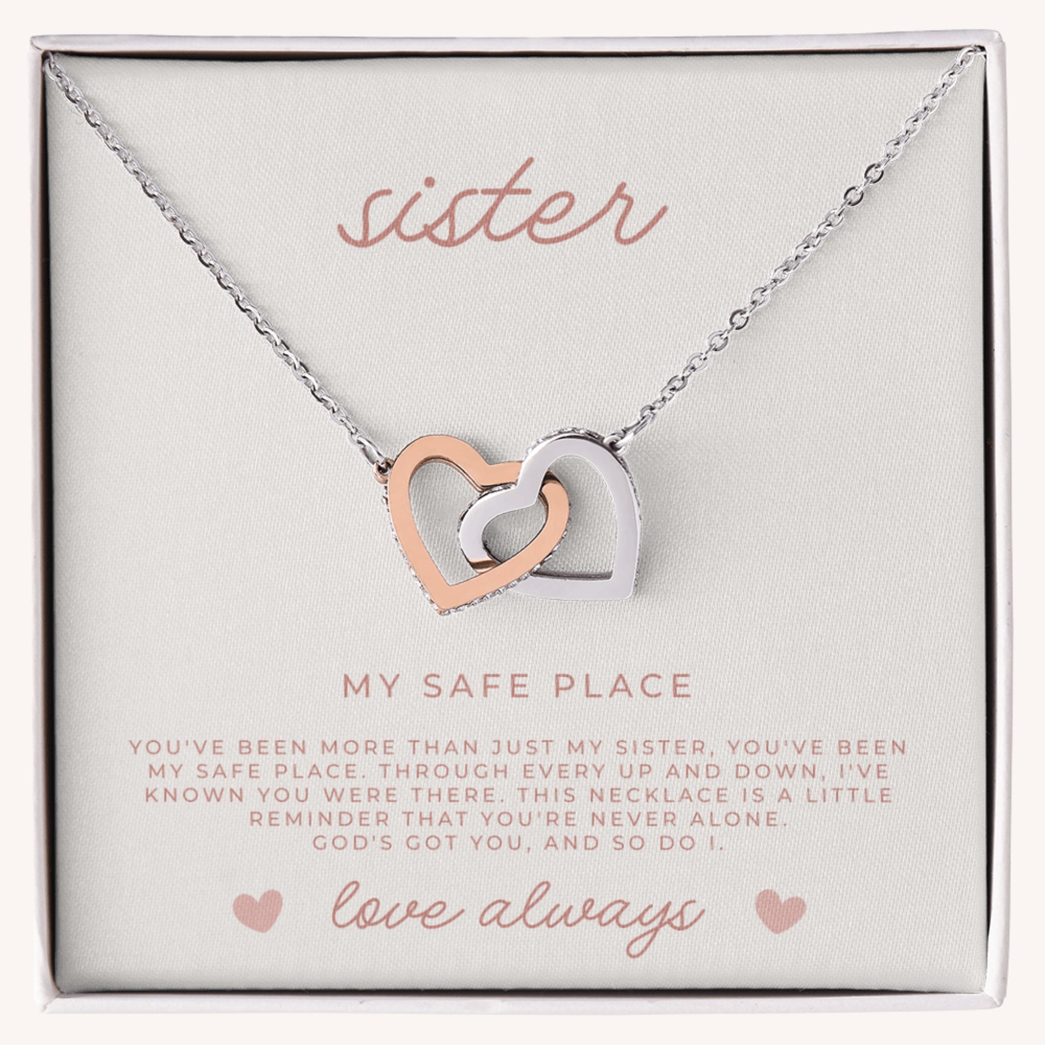 Silver and rose gold waterproof necklace with interlocking heart pendants on a card that reads 'sister, my safe place' and a faith filled message.