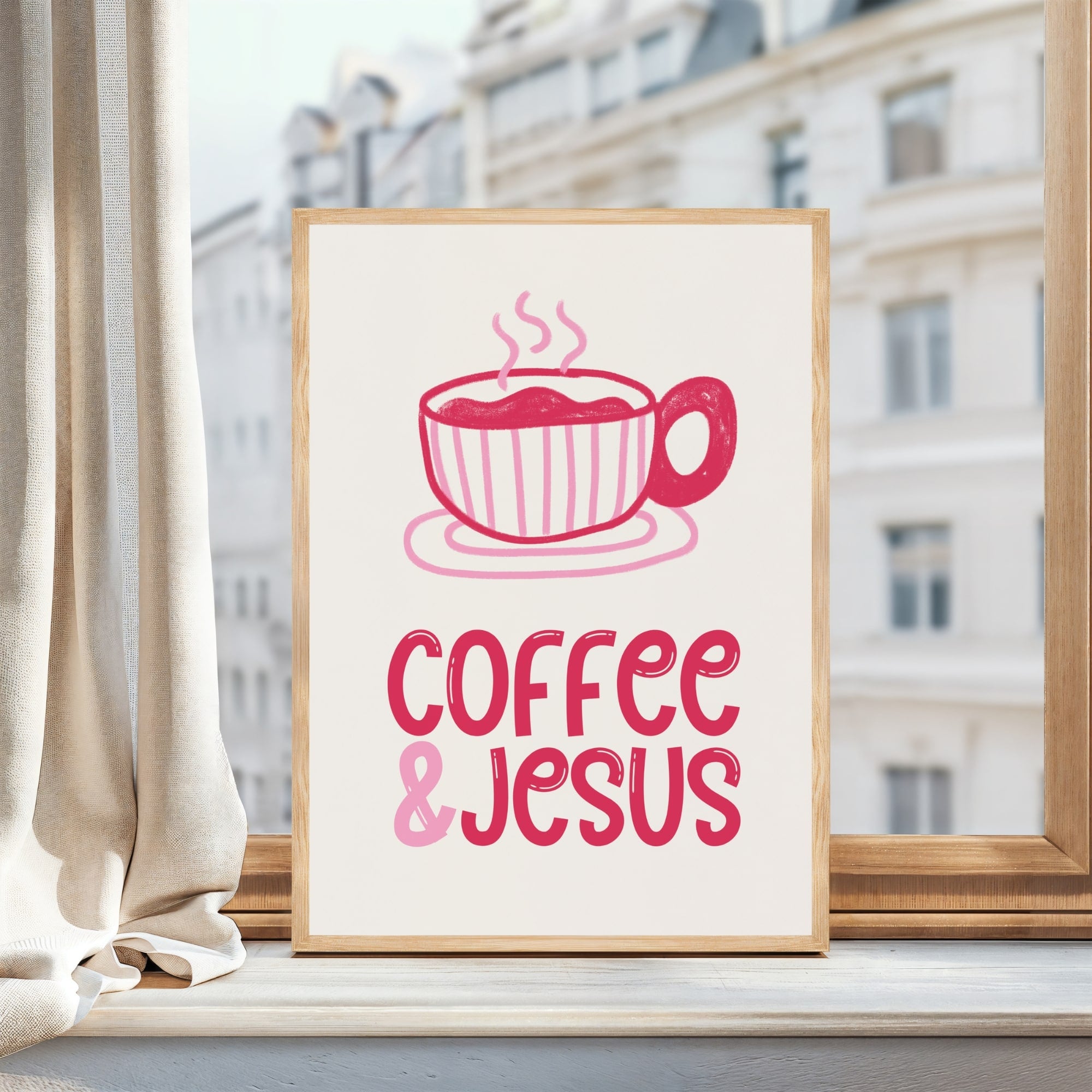 Framed print with a pink coffee cup and 'Coffee & Jesus' text, placed on a windowsill with a cityscape background.