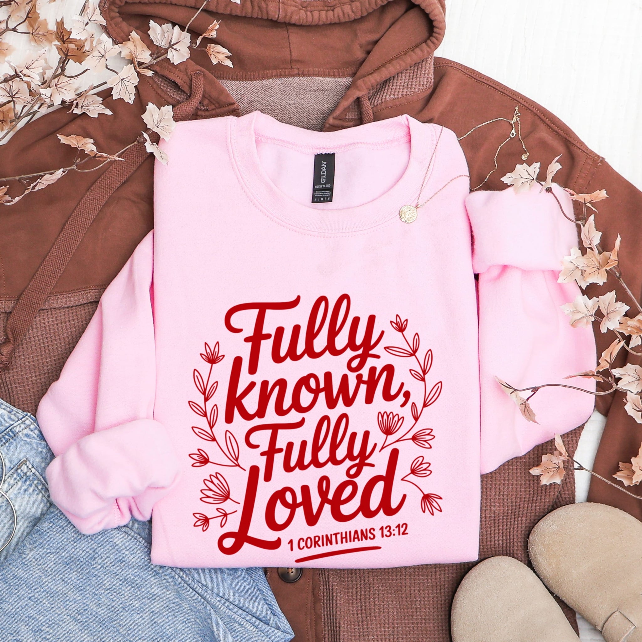 Pink Fully Known Fully Loved sweatshirt flat lay showing 1 Corinthians 13:12 design - inspirational Christian scripture apparel