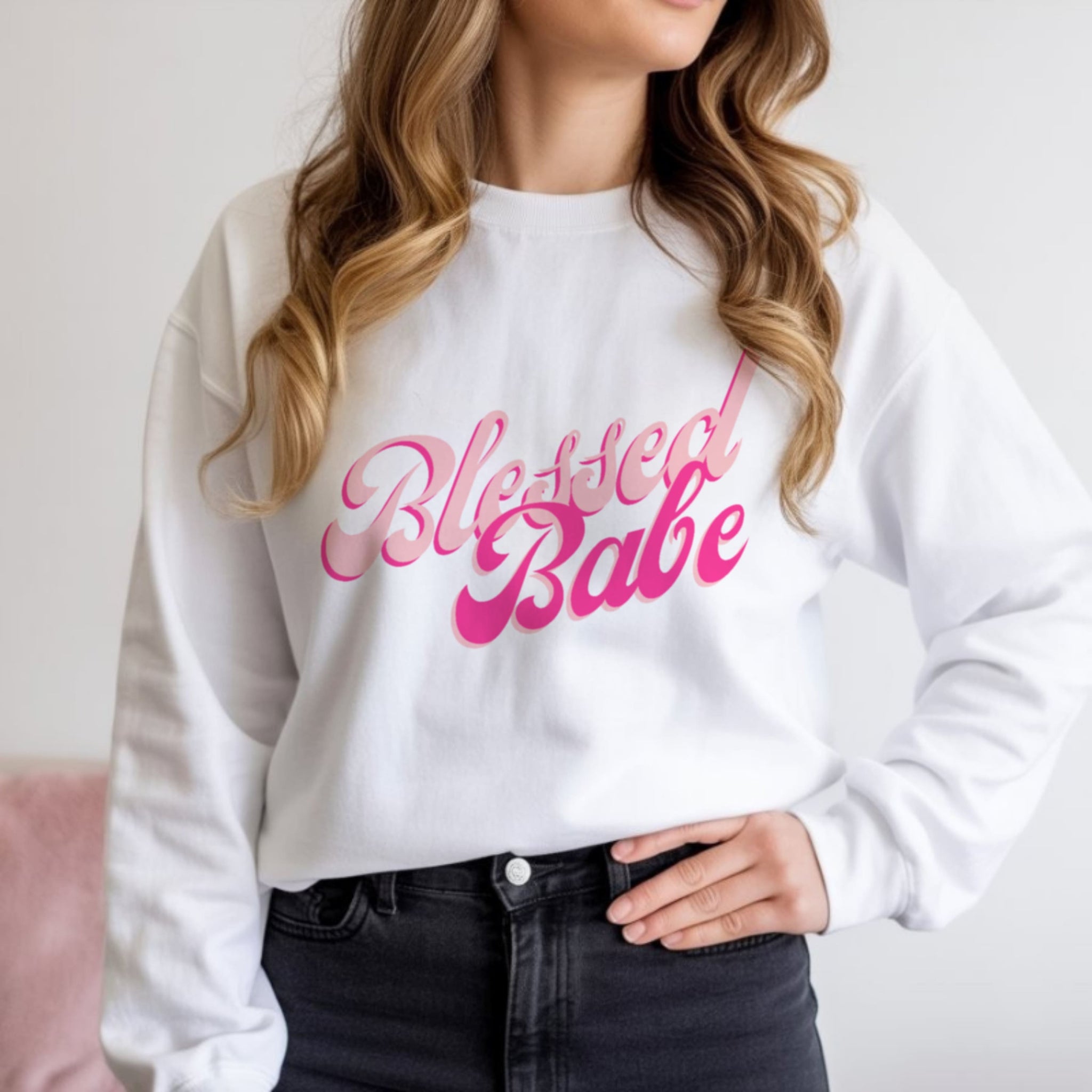  Woman wearing Blessed Babe white crewneck sweatshirt with jeans, trendy Christian faith fashion for women