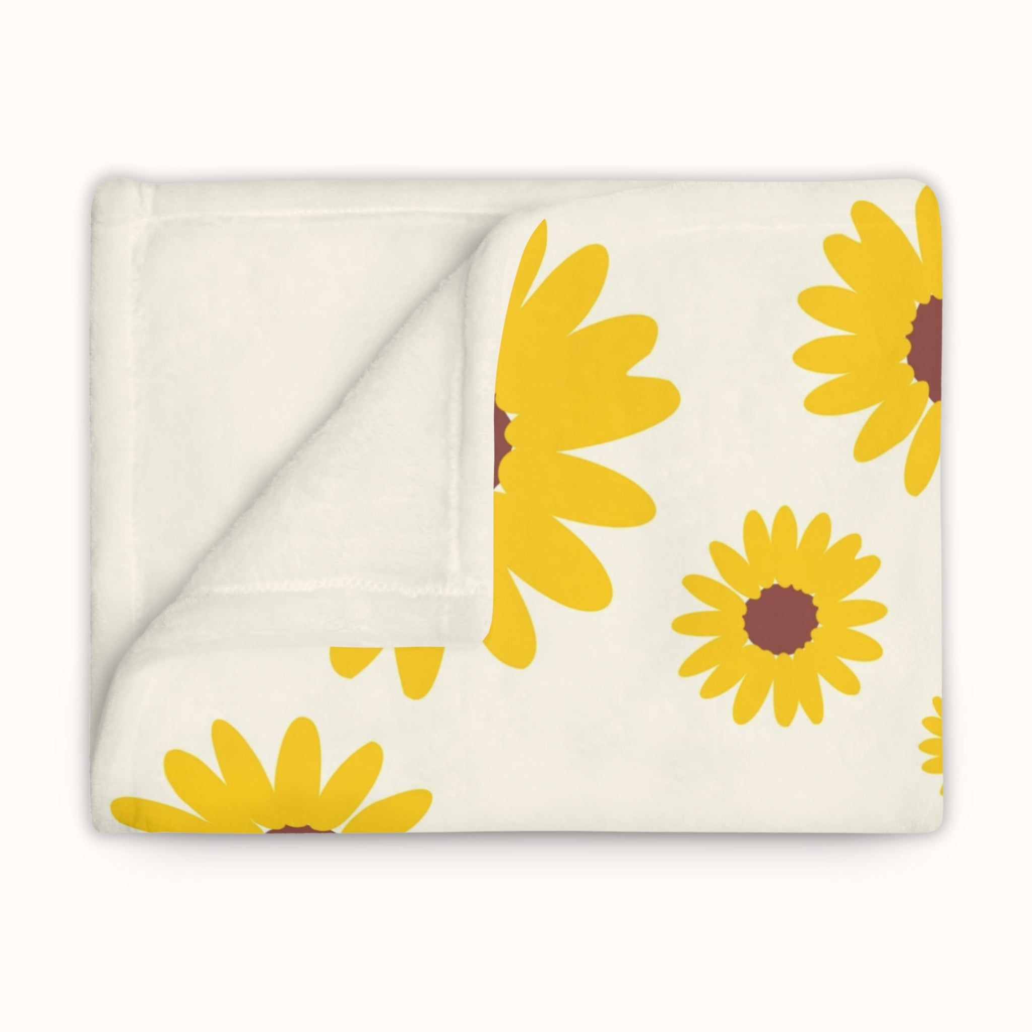 Folded blanket with yellow sunflower pattern on a white background