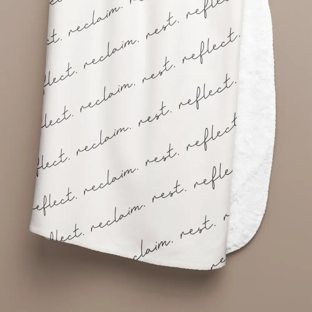 Premium sherpa throw from faithful hearts hanging to show close up of the blanket with the script style font saying rest reclaim reflect