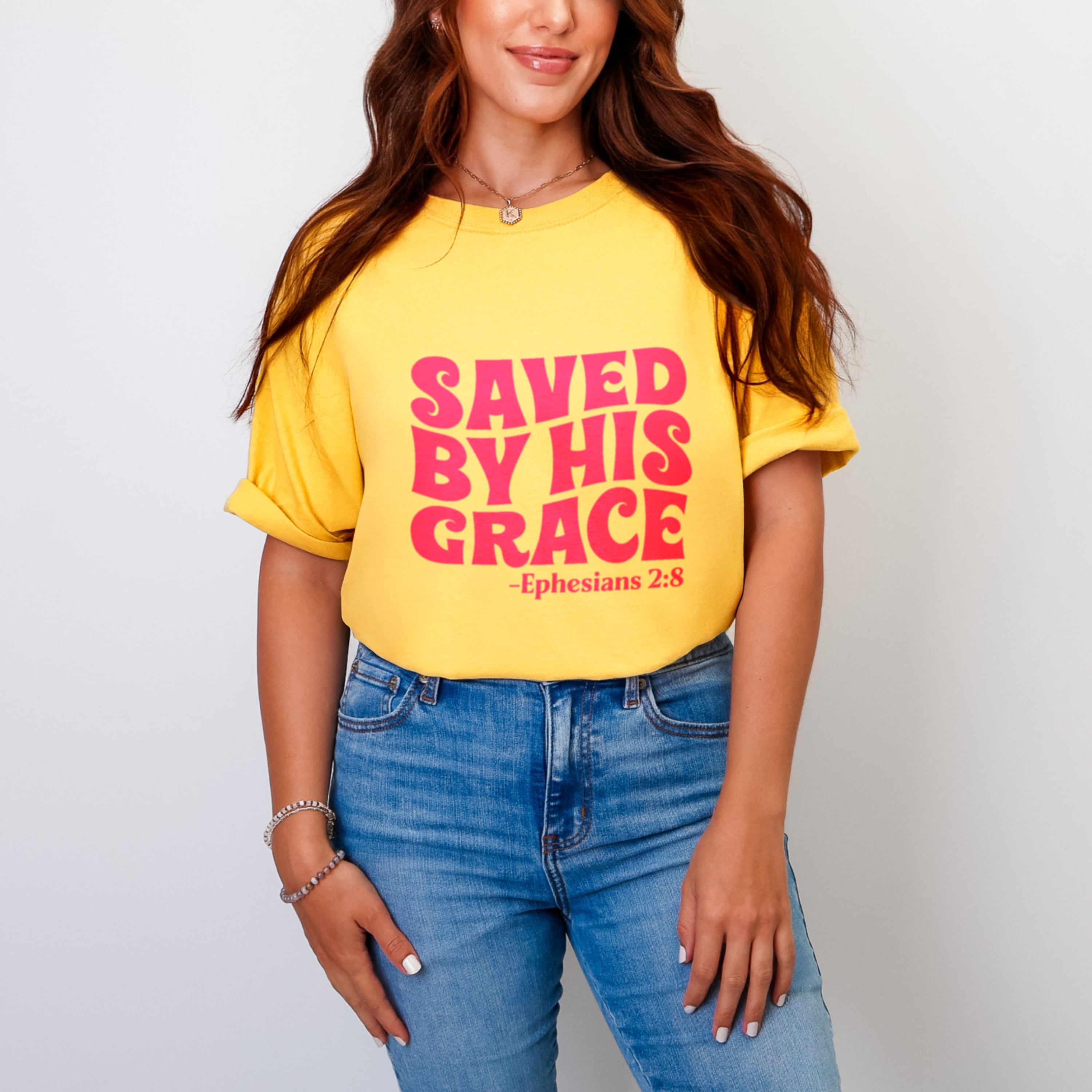Saved By His Grace scripture shirt in vibrant yellow with bold pink lettering, aesthetic Christian apparel for women